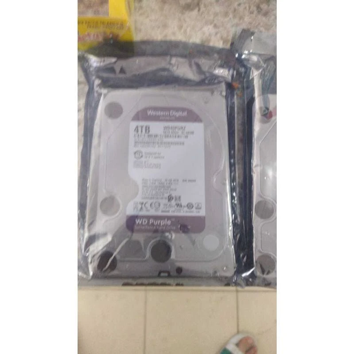 Un disco rigido da 4 TB in una confezione di plastica sigillata. "WD Purple" è visibile sull'etichetta.