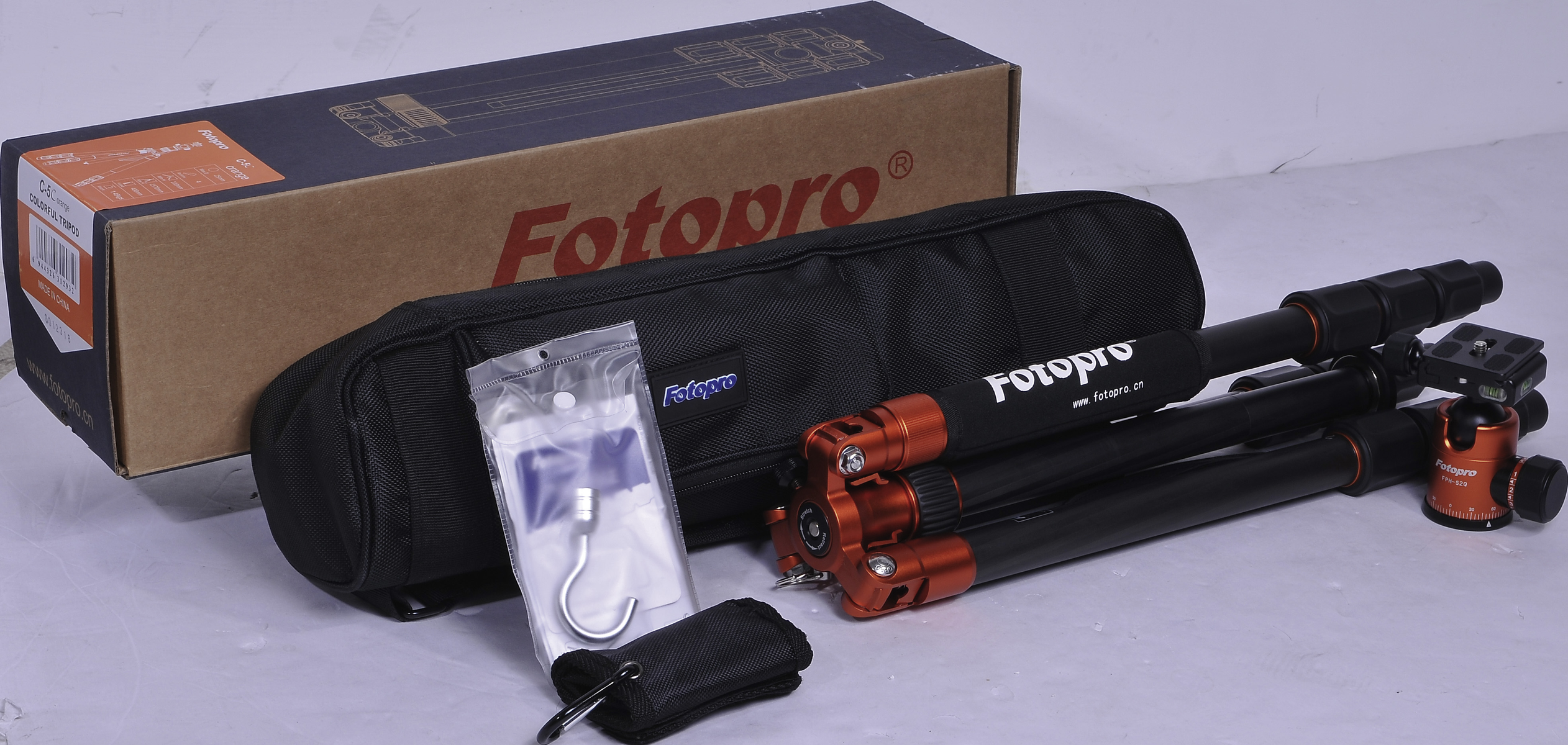 Zestaw statywu z pudełkiem, torbą i akcesoriami. Czarny statyw z pomarańczowymi detalami.