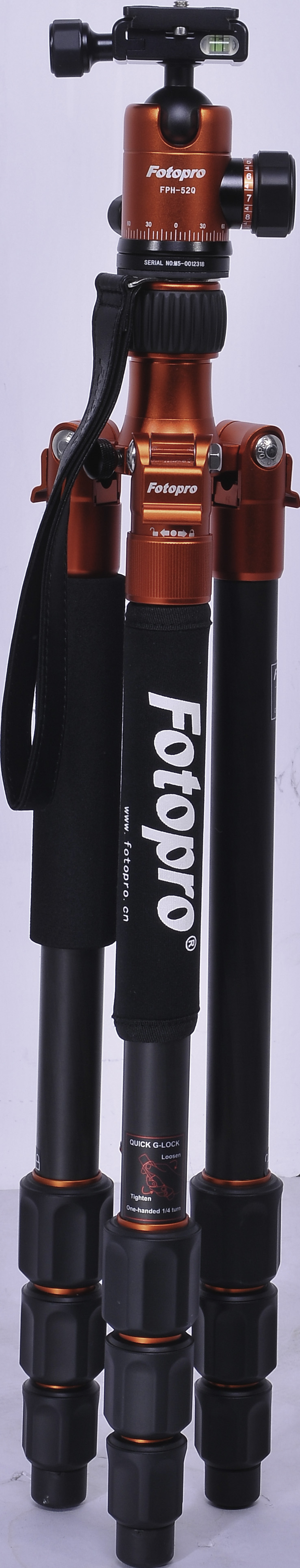 Brązowo-czarny statyw Fotopro z czarnym paskiem i pomarańczowymi akcentami.