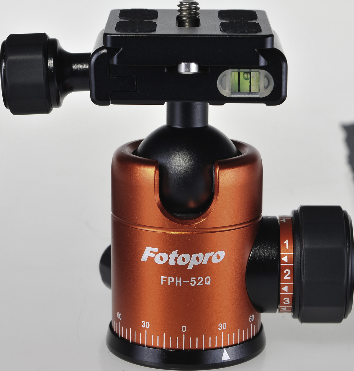 Pomarańczowo-czarna głowica statywu. Poziomica i cyfry do regulacji. Marka: Fotopro.