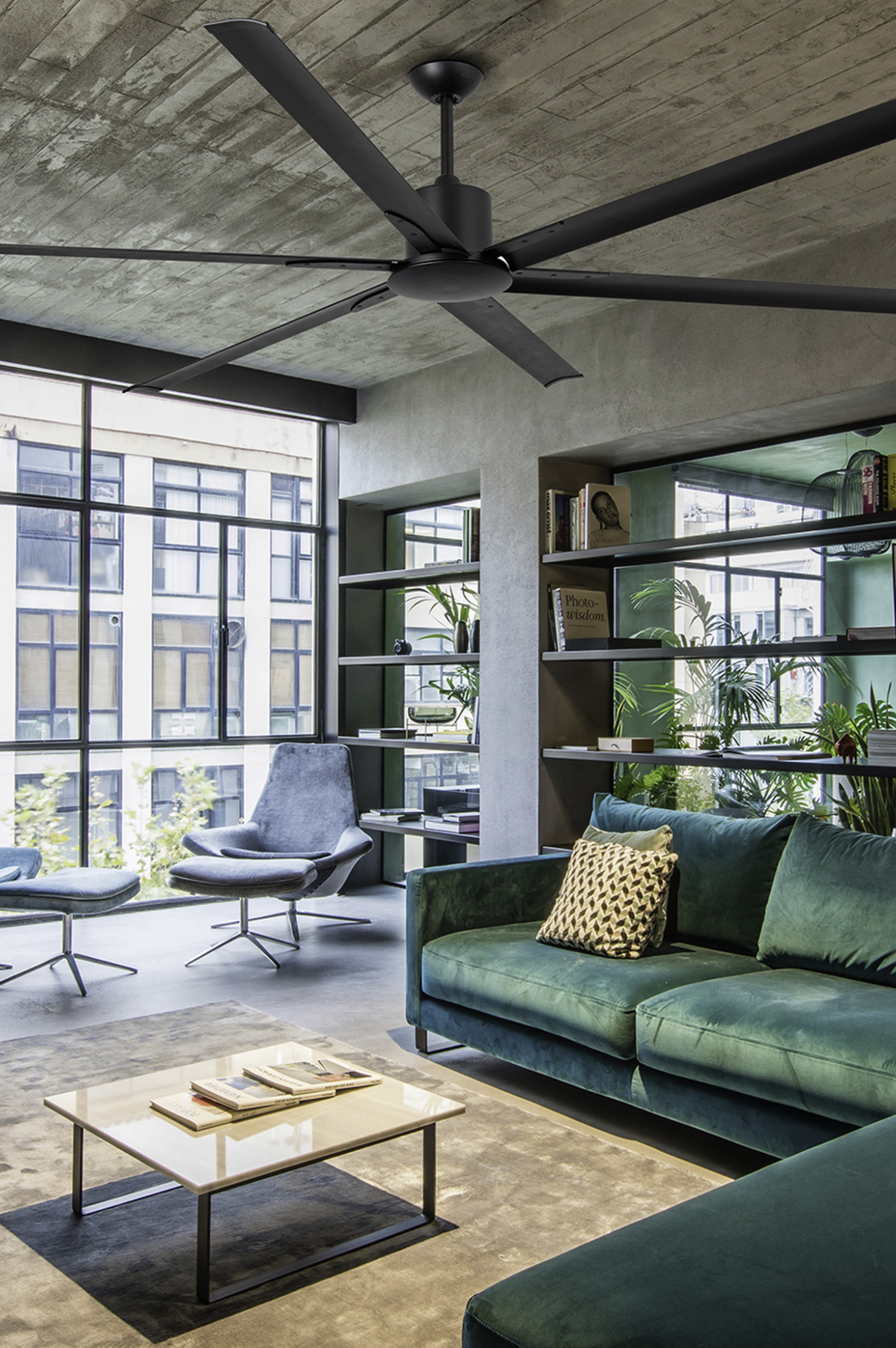Soggiorno moderno con divano verde acqua, ampia finestra, ventilatore a soffitto nero e mensole.