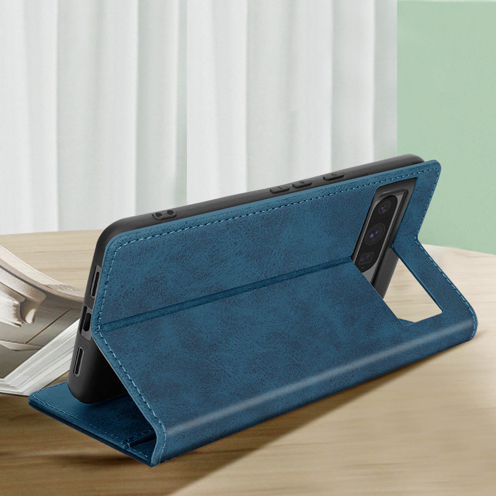 Custodia blu per telefono aperta, con un telefono. Sfondo in legno chiaro.