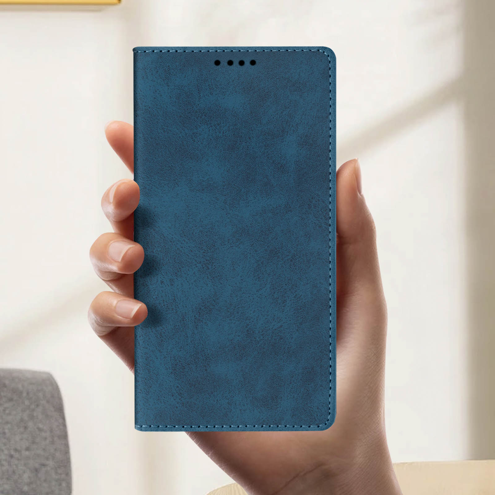 Custodia per telefono in pelle blu. È tenuta in mano e ha un bordo cucito.