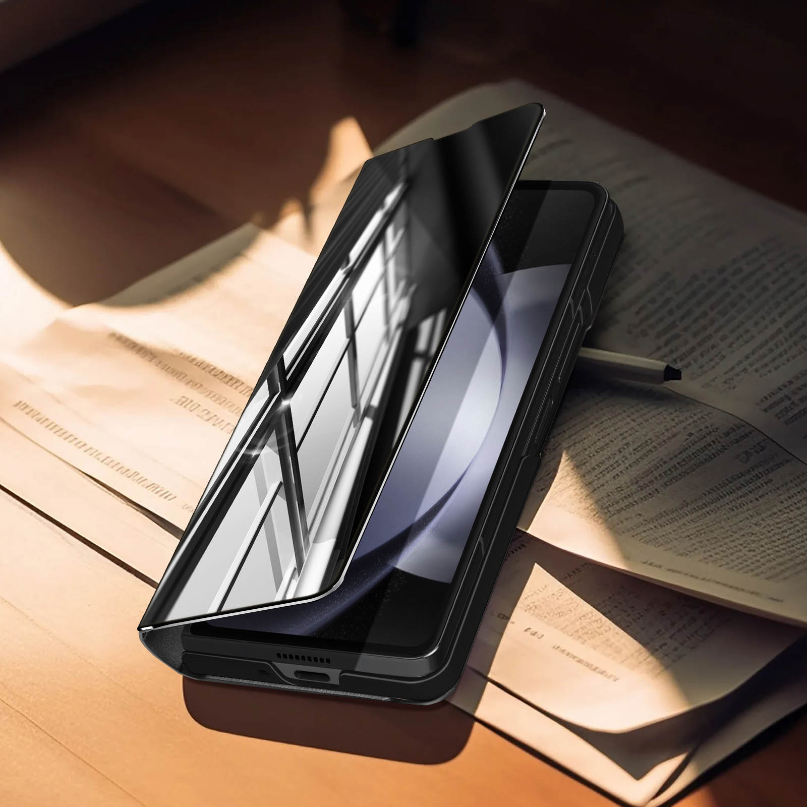Custodia per telefono nera con copertura a specchio, aperta su una superficie di legno con una penna.