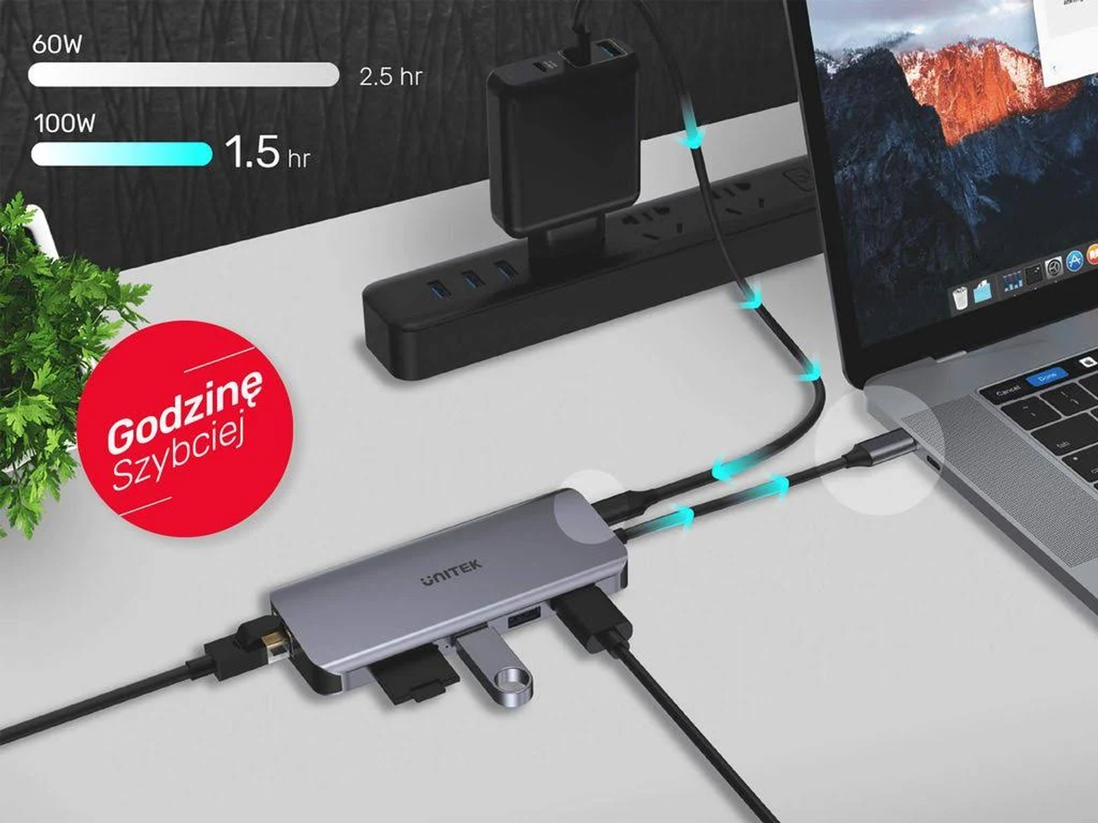 Un hub USB argentato collegato a un laptop, una presa di corrente e altri dispositivi. Mostra la velocità di carica.