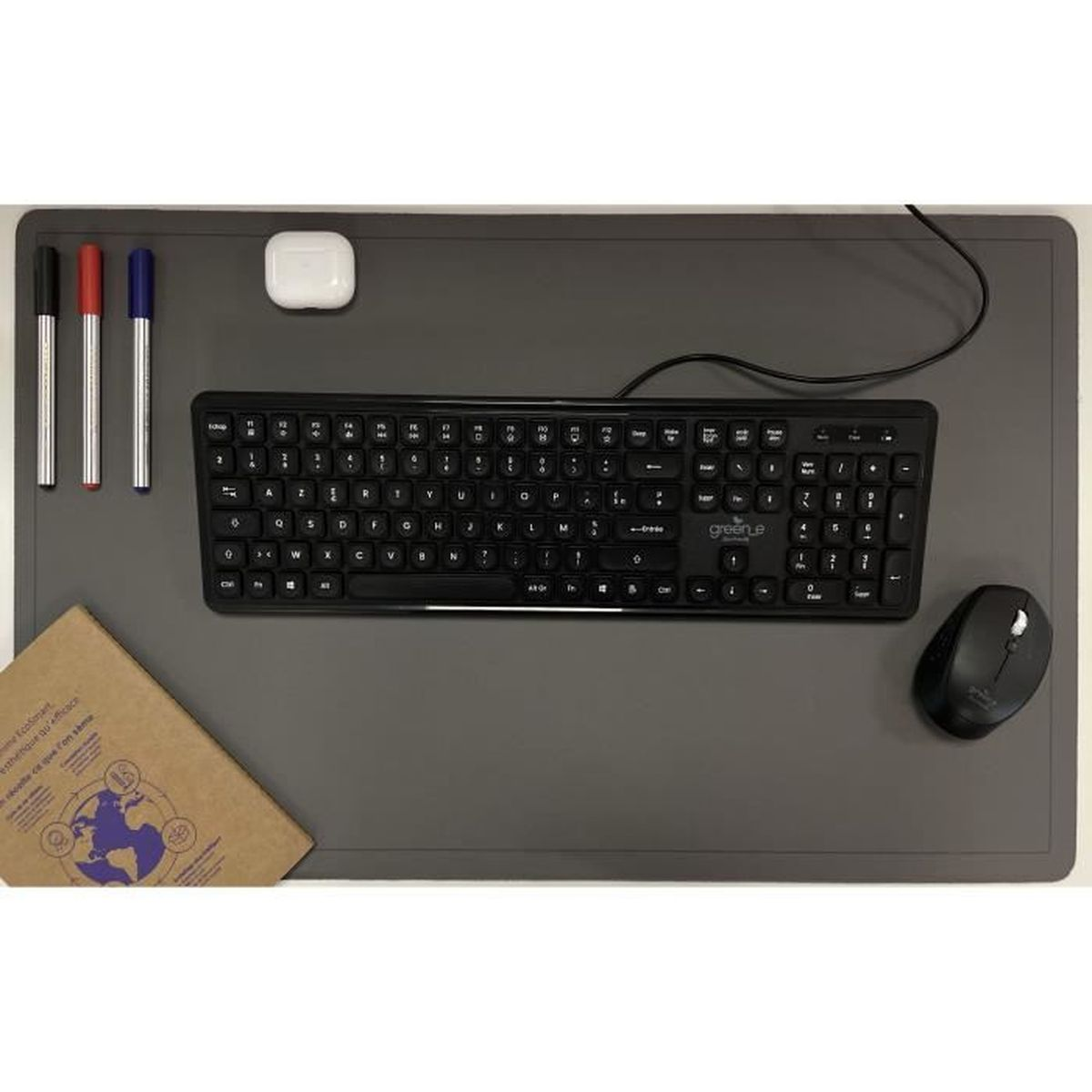 Un sottomano grigio con tastiera nera, mouse, tre penne, custodia per auricolari e un libro.