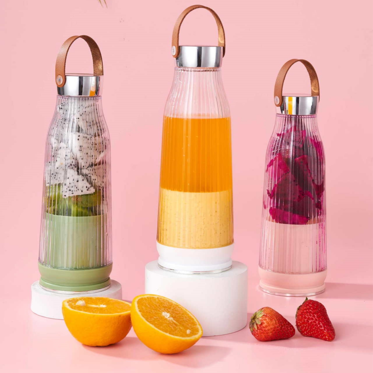 Drei Mixer mit Obst: Drachenfrucht, Orangensaft und Erdbeersaft.