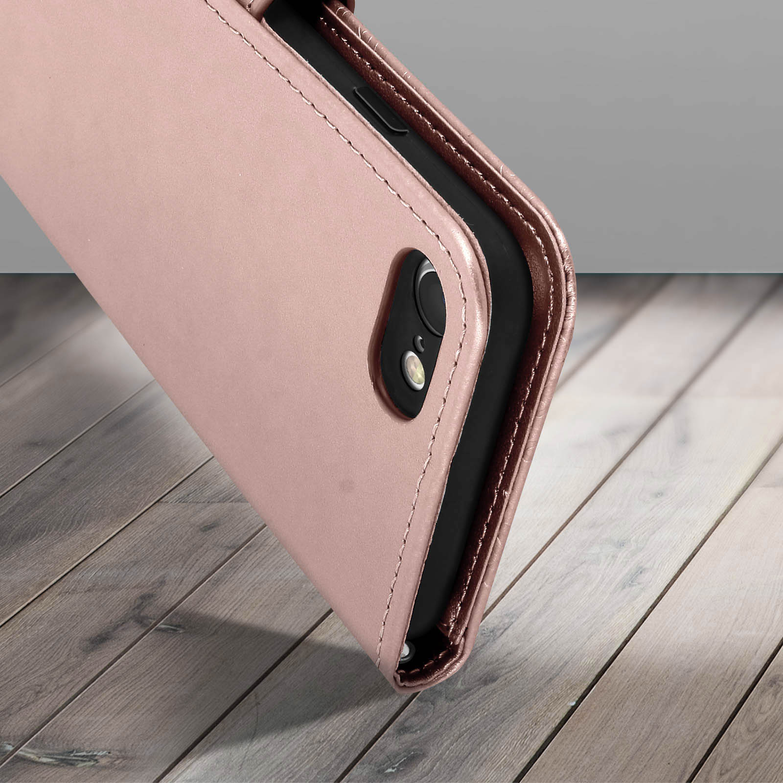 Primo piano di una custodia per telefono rosa. È una custodia a portafoglio, con un dettaglio di cucitura.