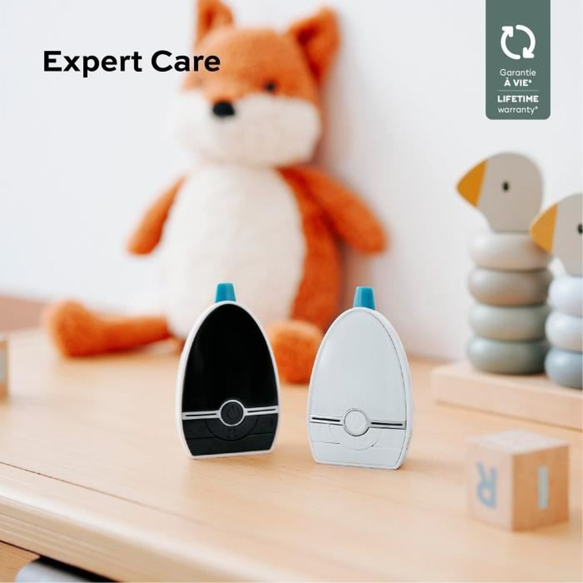 Zwei schwarz-weiße Babyphone auf einem Holztisch. Ein Fuchstier ist dahinter.