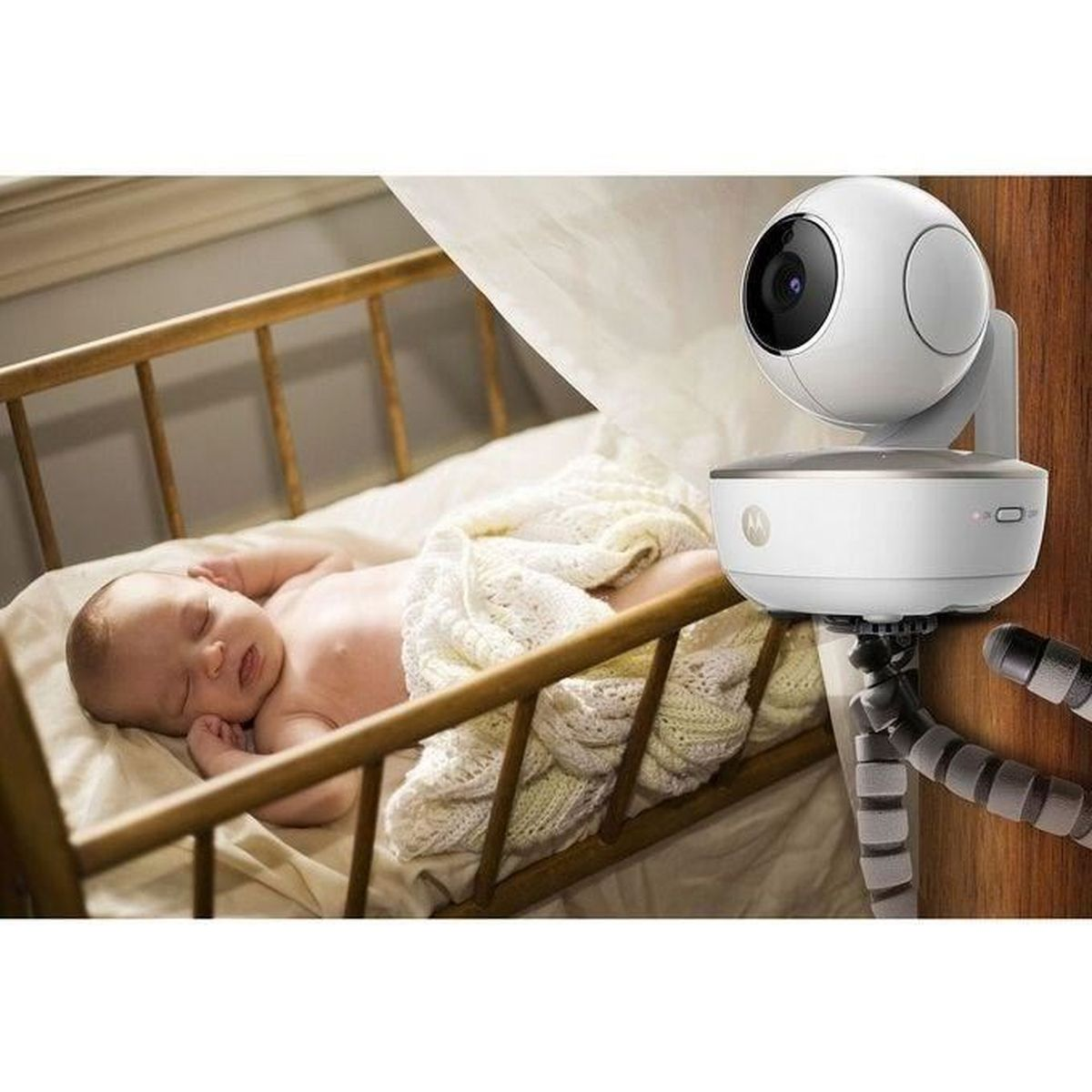 Baby schläft in einem Kinderbett, bewacht von einem weißen Babyphone. Monitor steht auf einem flexiblen Ständer.