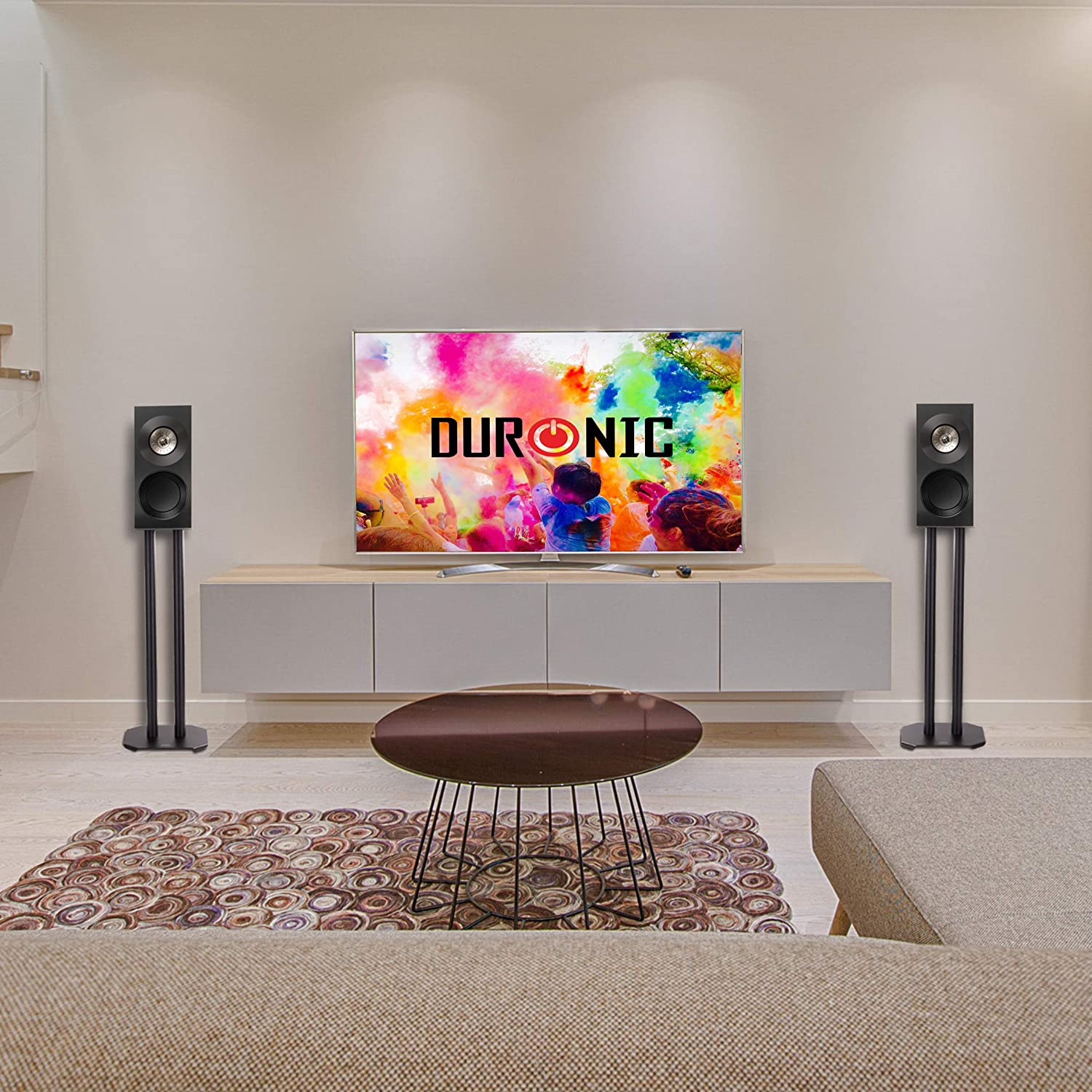Wohnzimmer mit Fernseher, Lautsprechern, Couchtisch und Sofa; Bildschirm zeigt 'DURONIC'.