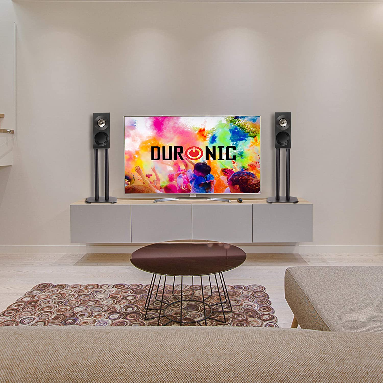 Ein Wohnzimmer mit TV, Lautsprechern und einem Couchtisch.