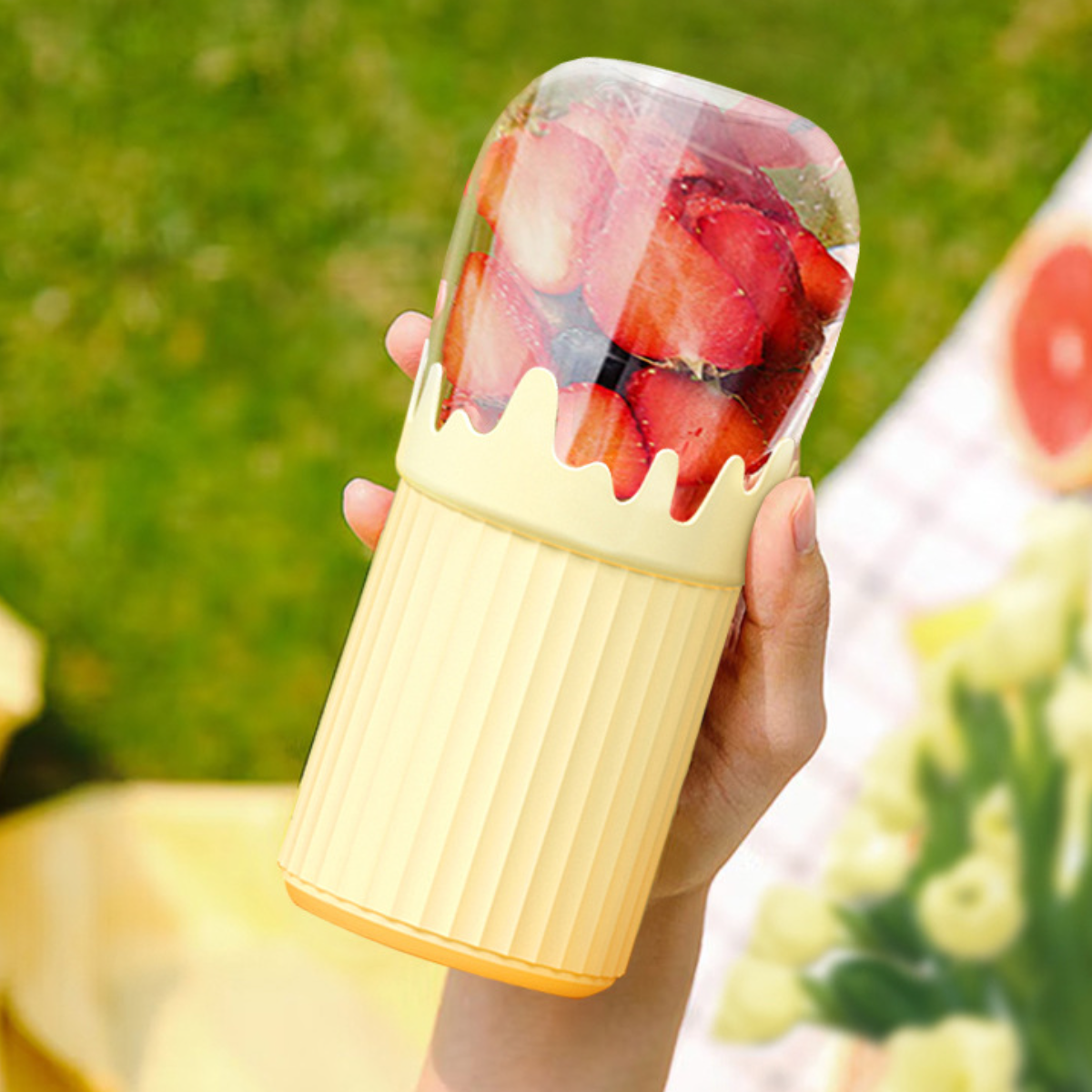 Eine Person hält einen Behälter mit Erdbeeren. Der Hintergrund hat eine Grapefruit.