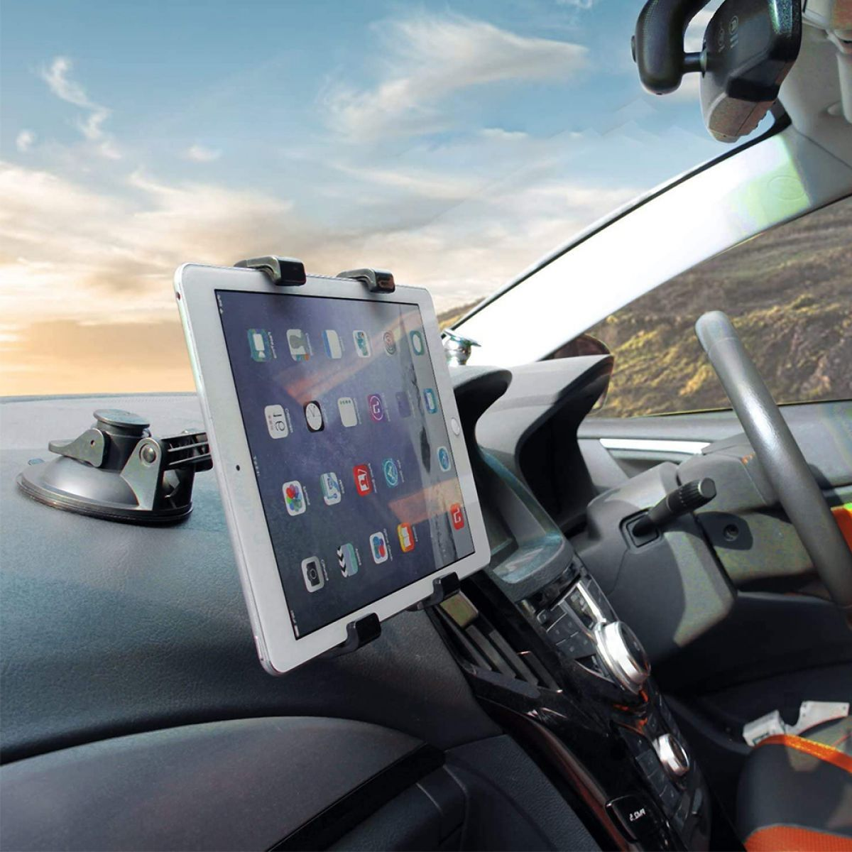 Tablet auf dem Armaturenbrett montiert, sonniger Himmel im Hintergrund. Das Tablet zeigt Apps.