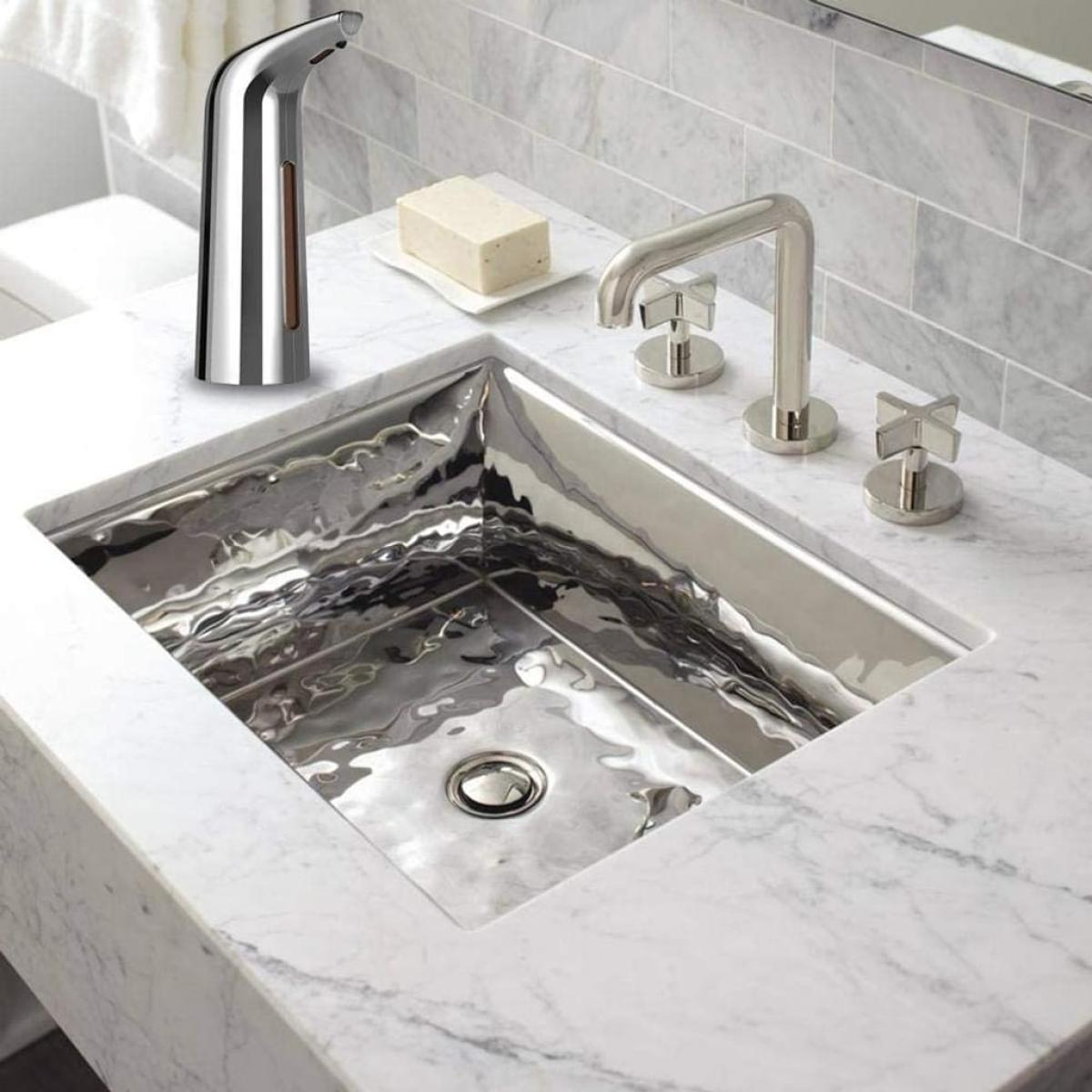 Ein Edelstahlbecken mit Chromarmatur und Seifenspender.
