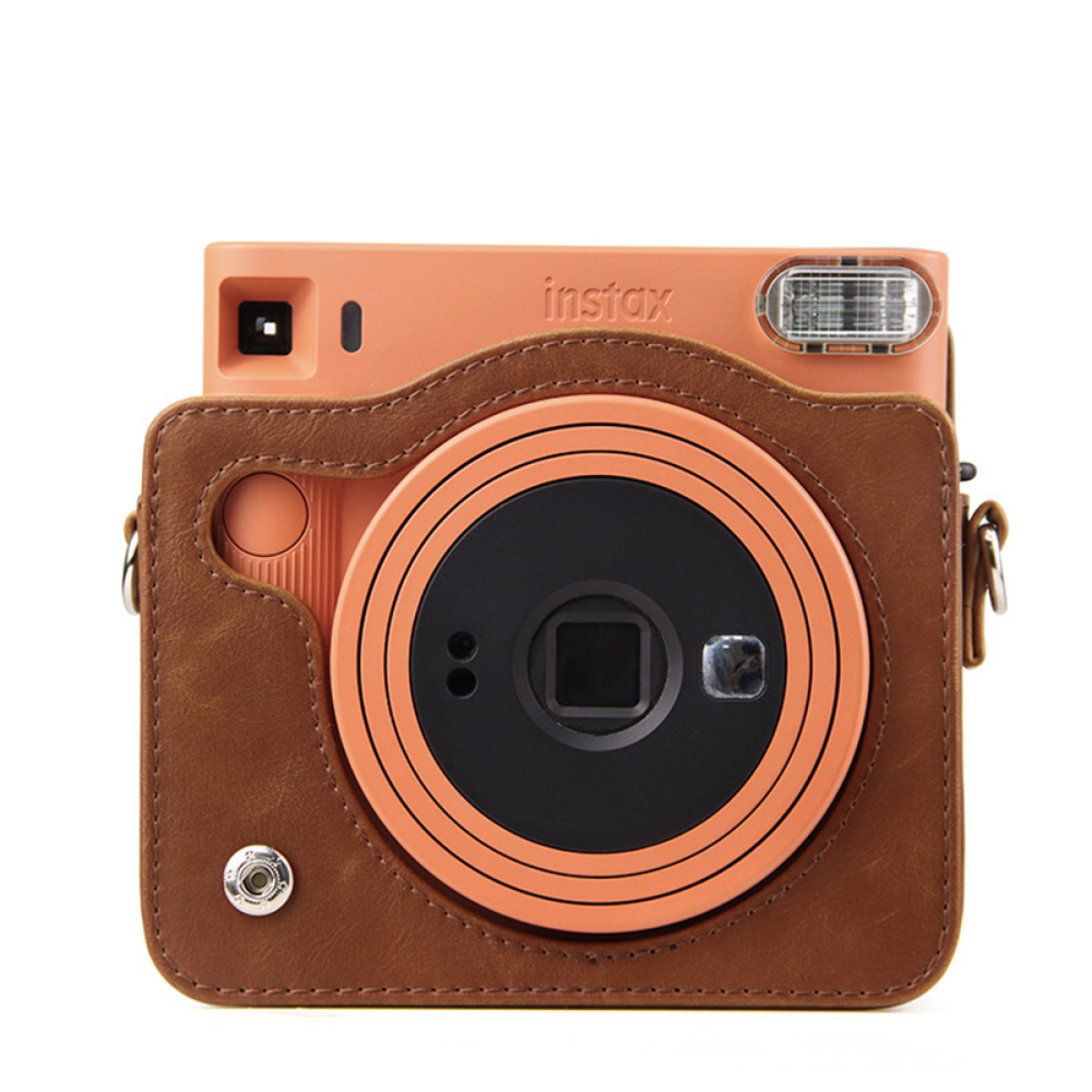 Eine orangefarbene Instax-Kamera in einer braunen Ledertasche. Die Kamera steht auf weißem Hintergrund.