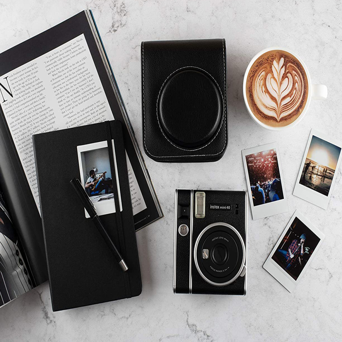 Kamera, Hülle, Notizbuch, Stift, Kaffee und Fotos auf Marmoroberfläche.