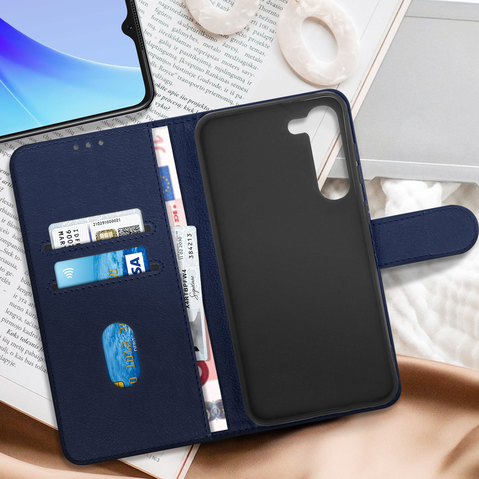 Custodia blu per telefono con carte di credito e contanti, aperta su un tavolo.