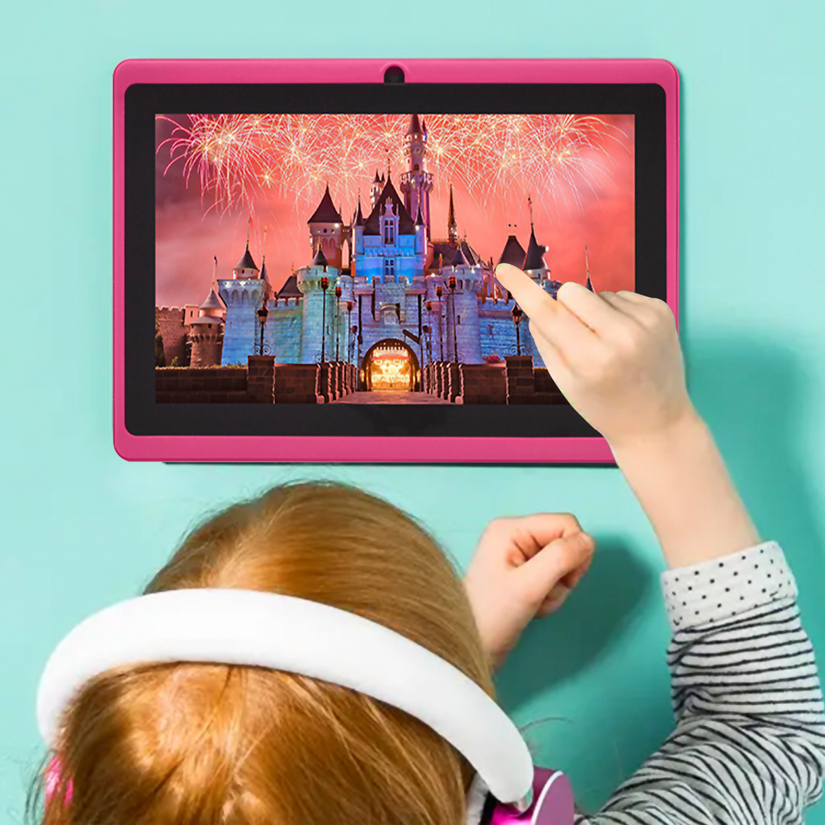 Ein Kind benutzt ein Tablet, das eine Burg- und Feuerwerkszene zeigt.