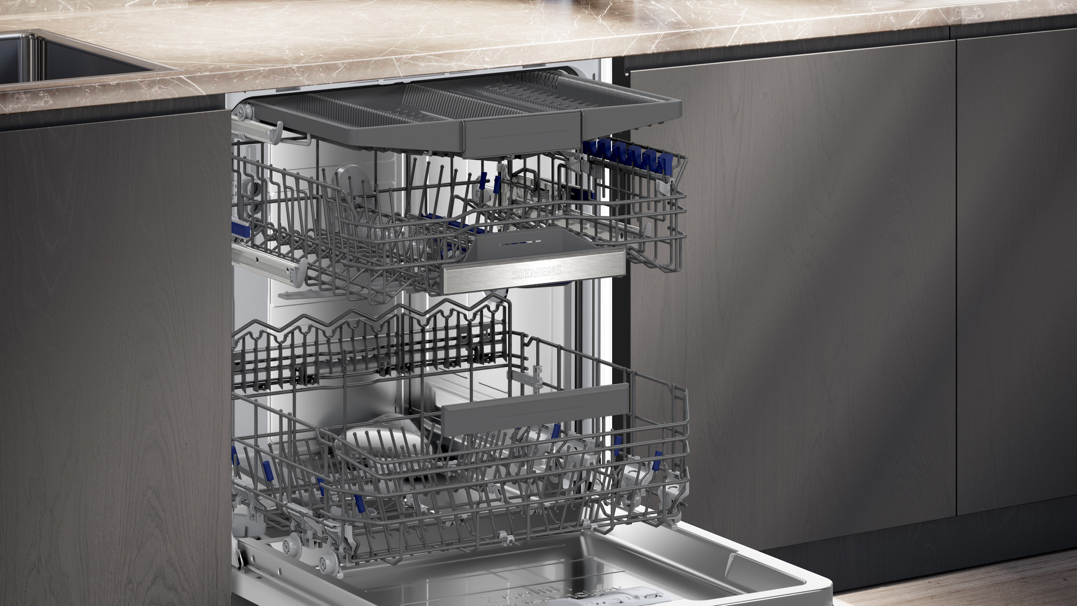 Dishwasher interior: two racks with dishes, against gray kitchen wall.
