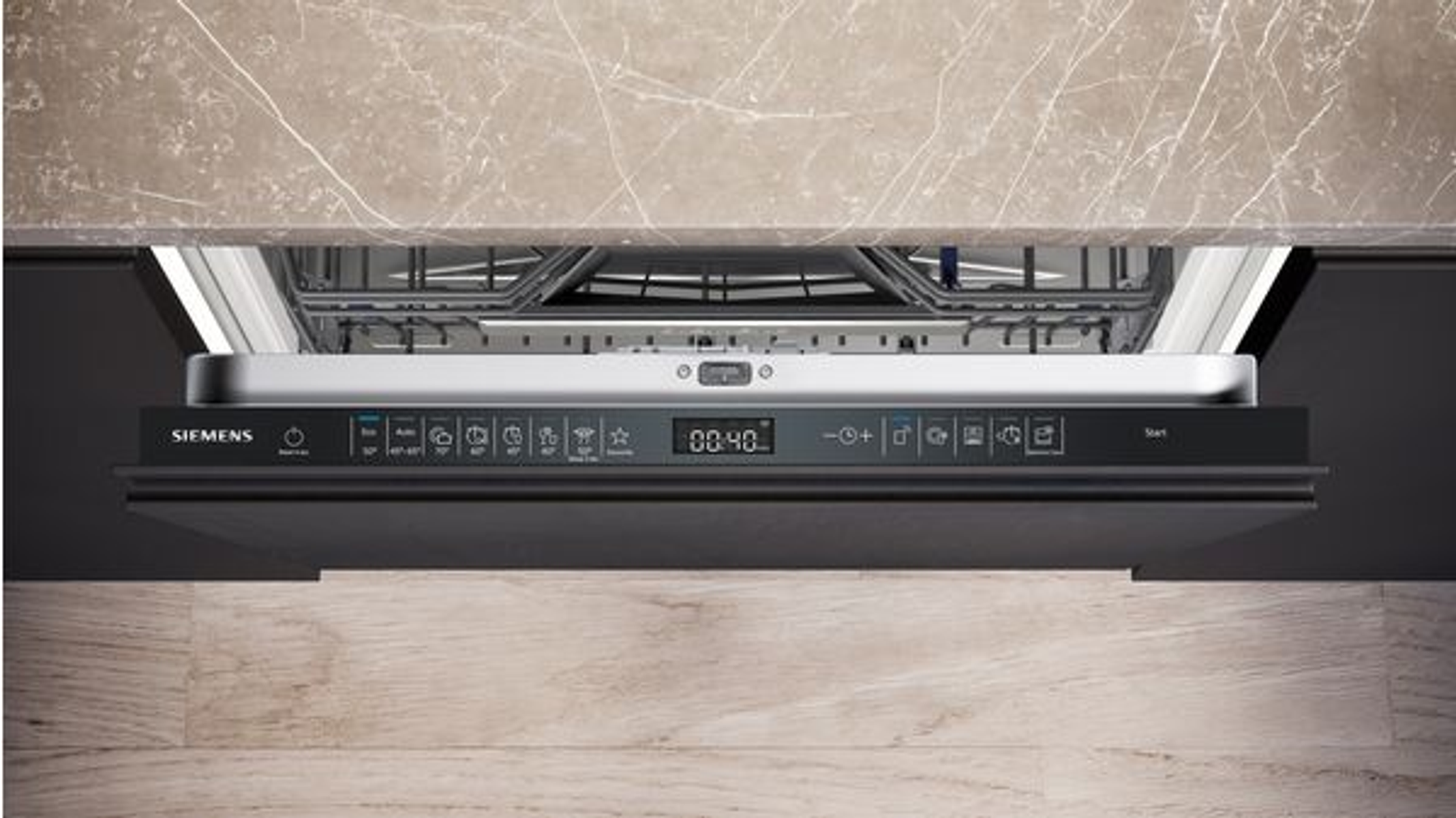 Zmywarka z otwartymi drzwiami, panel sterowania i marmurowy blat w tle.