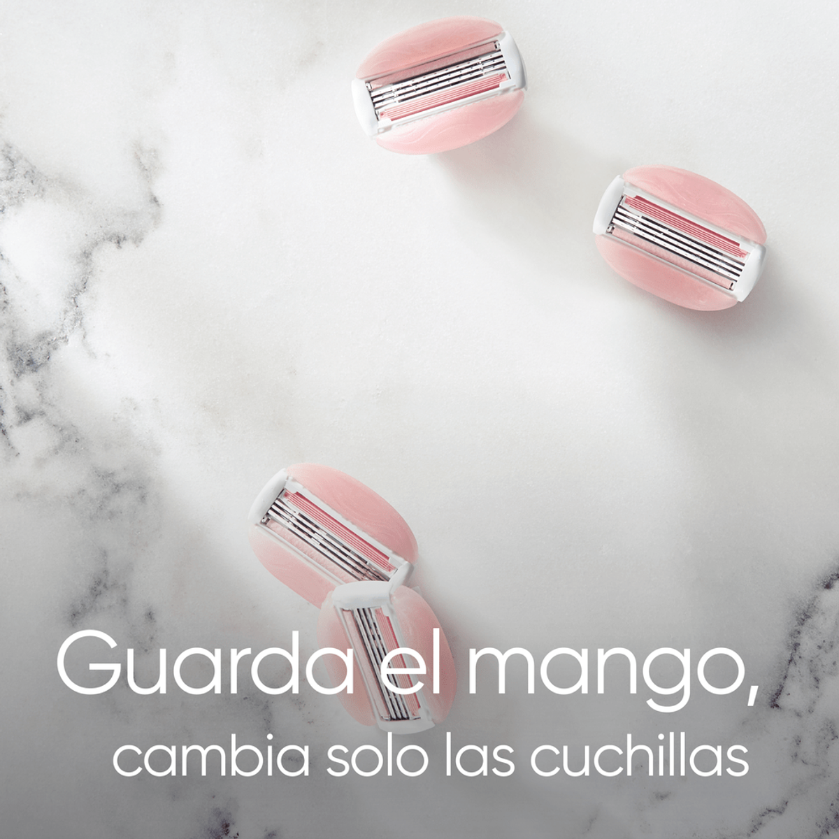 Cuatro cuchillas de afeitar rosas sobre una superficie de mármol blanco. Texto: "Guarda el mango, cambia solo las cuchillas."