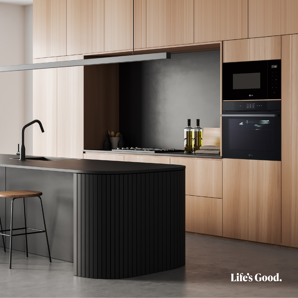 Cocina moderna con armarios de madera y electrodomésticos negros. Incluye horno, microondas e isla de cocina.
