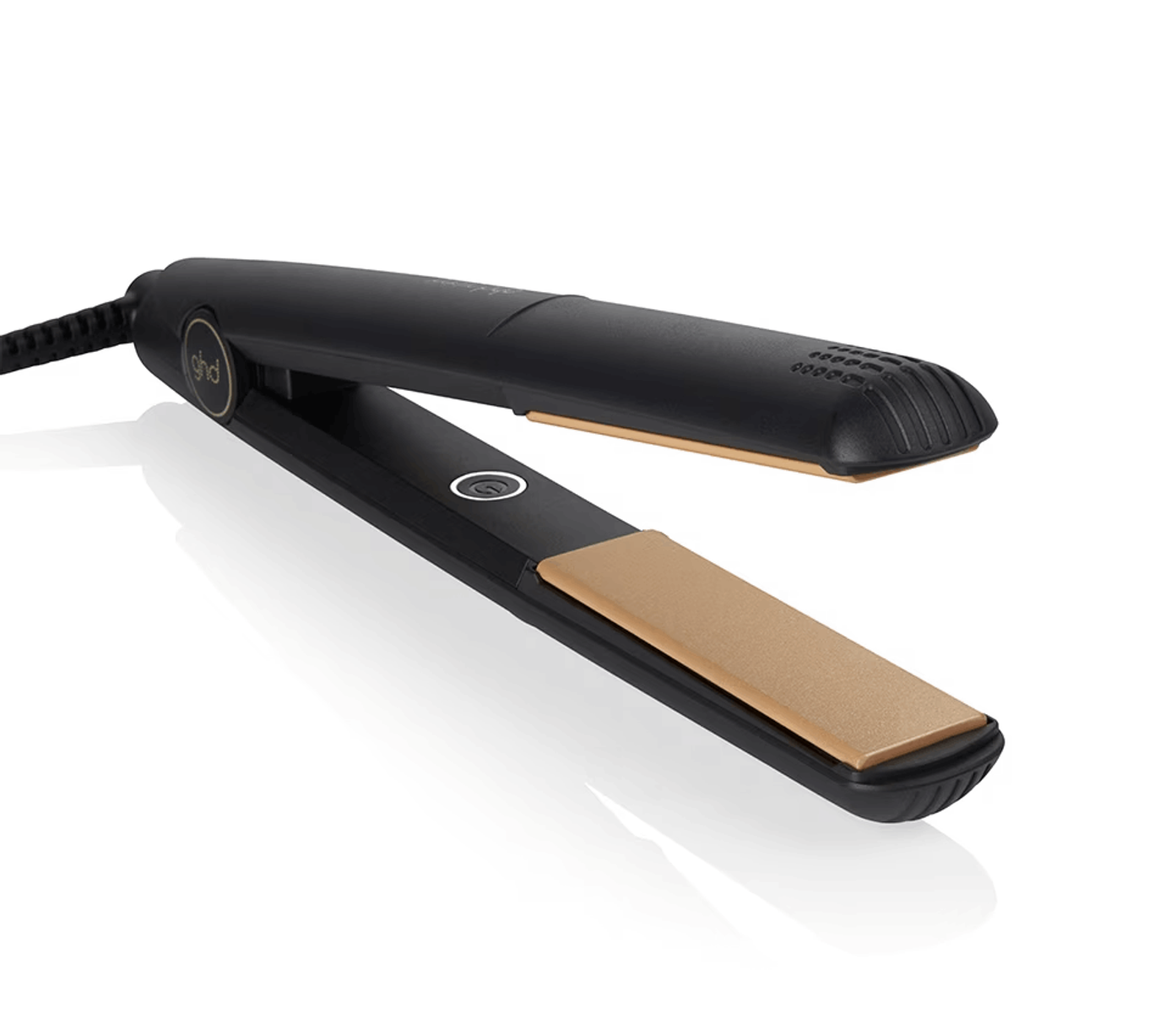 Schwarzer Haarglätter mit Goldplatten, der auf einer weißen Oberfläche liegt.