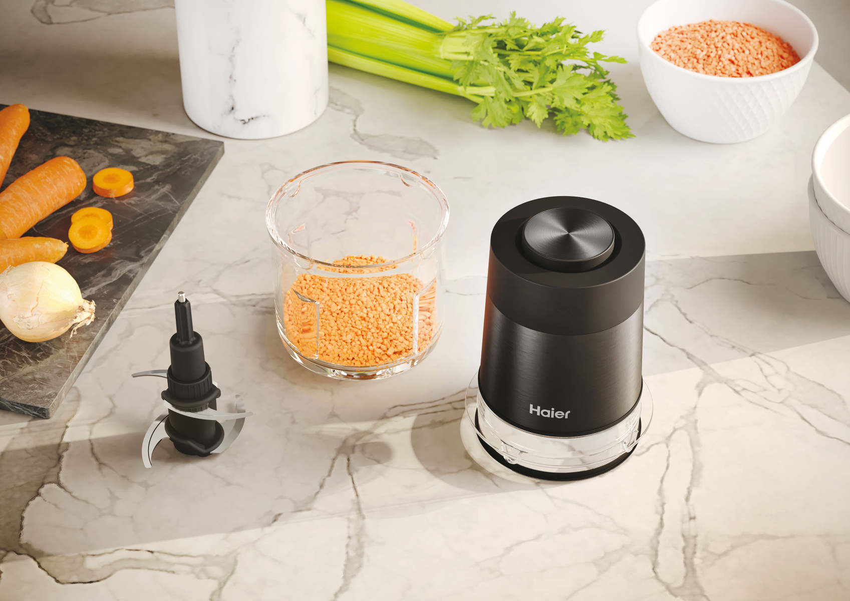 Un robot da cucina con lenticchie, sedano e carote su una superficie di marmo. Un robot nero sulla destra.