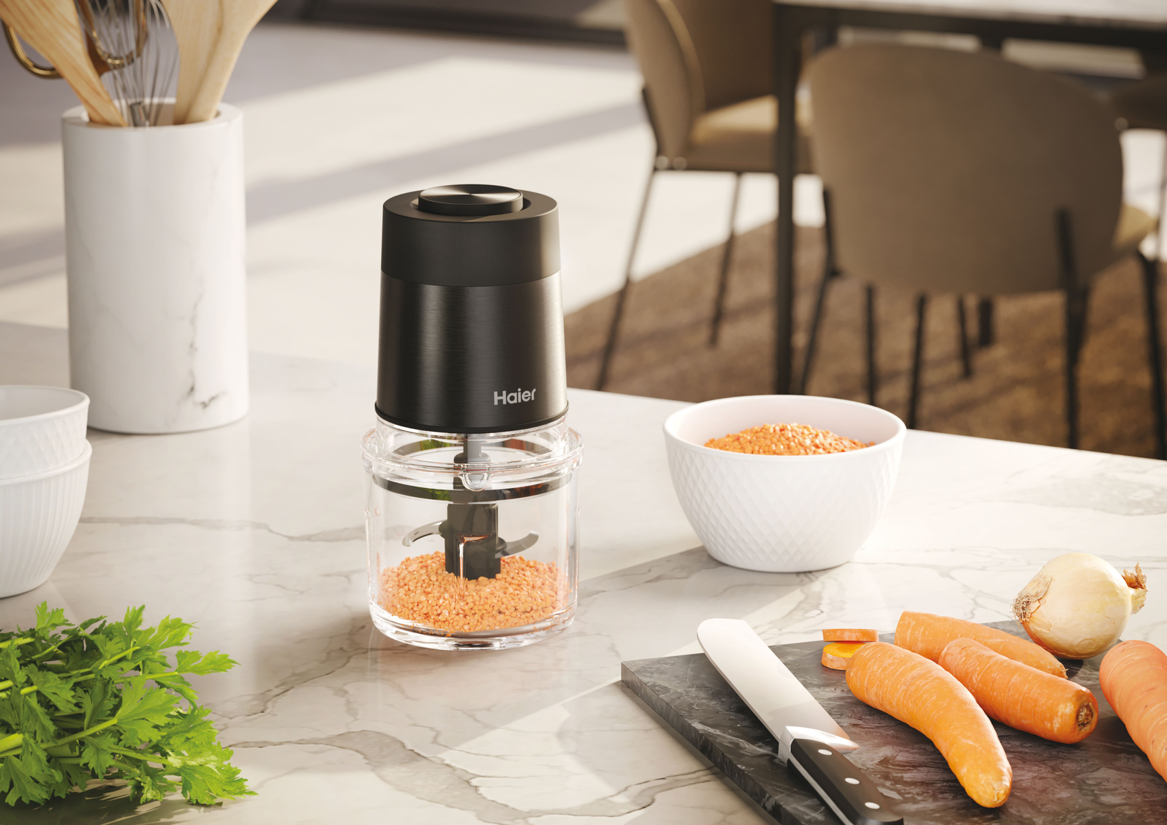 Tritatutto Haier nero con ingredienti su superficie in marmo. Sfondo bianco.