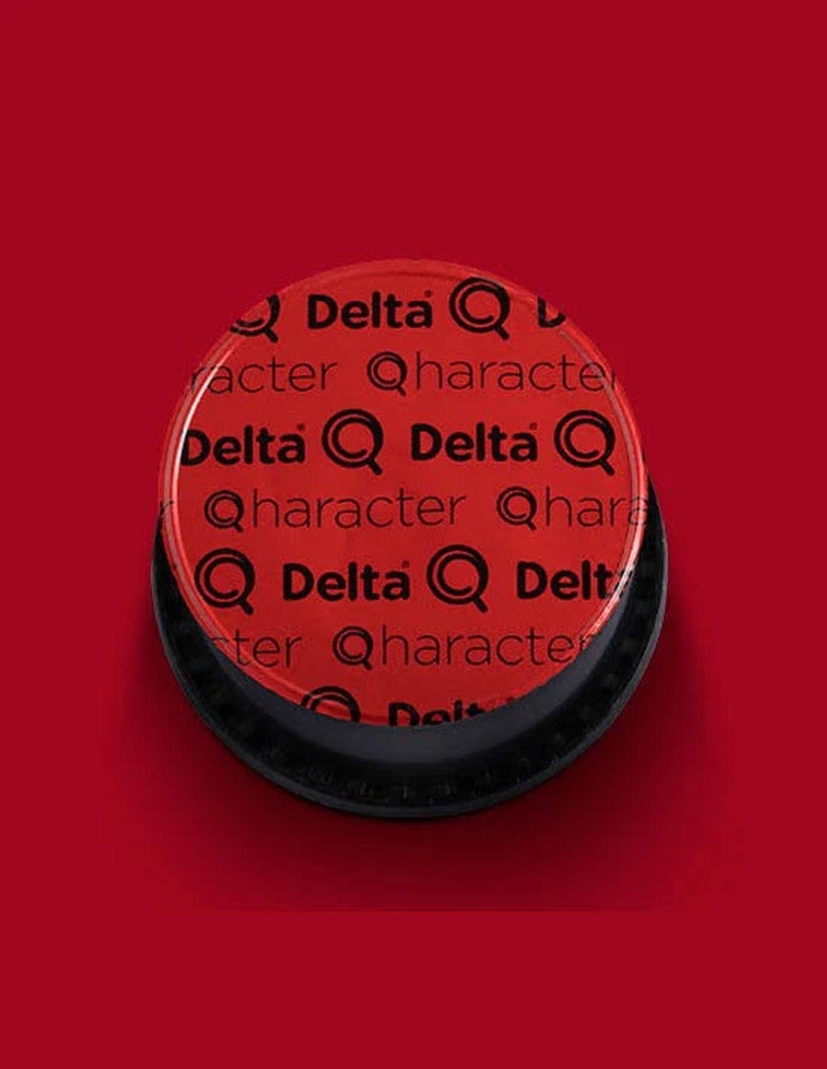 Oggetto circolare rosso con motivo ripetuto di testo nero 'Delta Q Character'.
