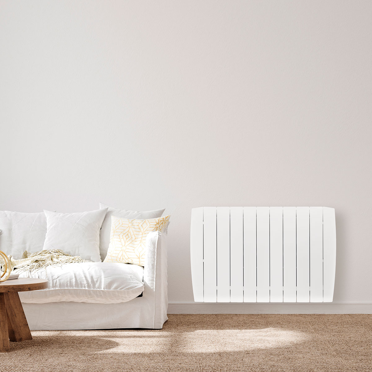 Sofá blanco y calefactor de pared en habitación blanca con alfombra.
