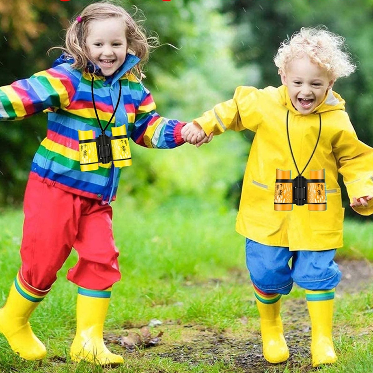Zwei Kinder rennen mit Ferngläsern um den Hals. Sie tragen bunte Regenkleidung.