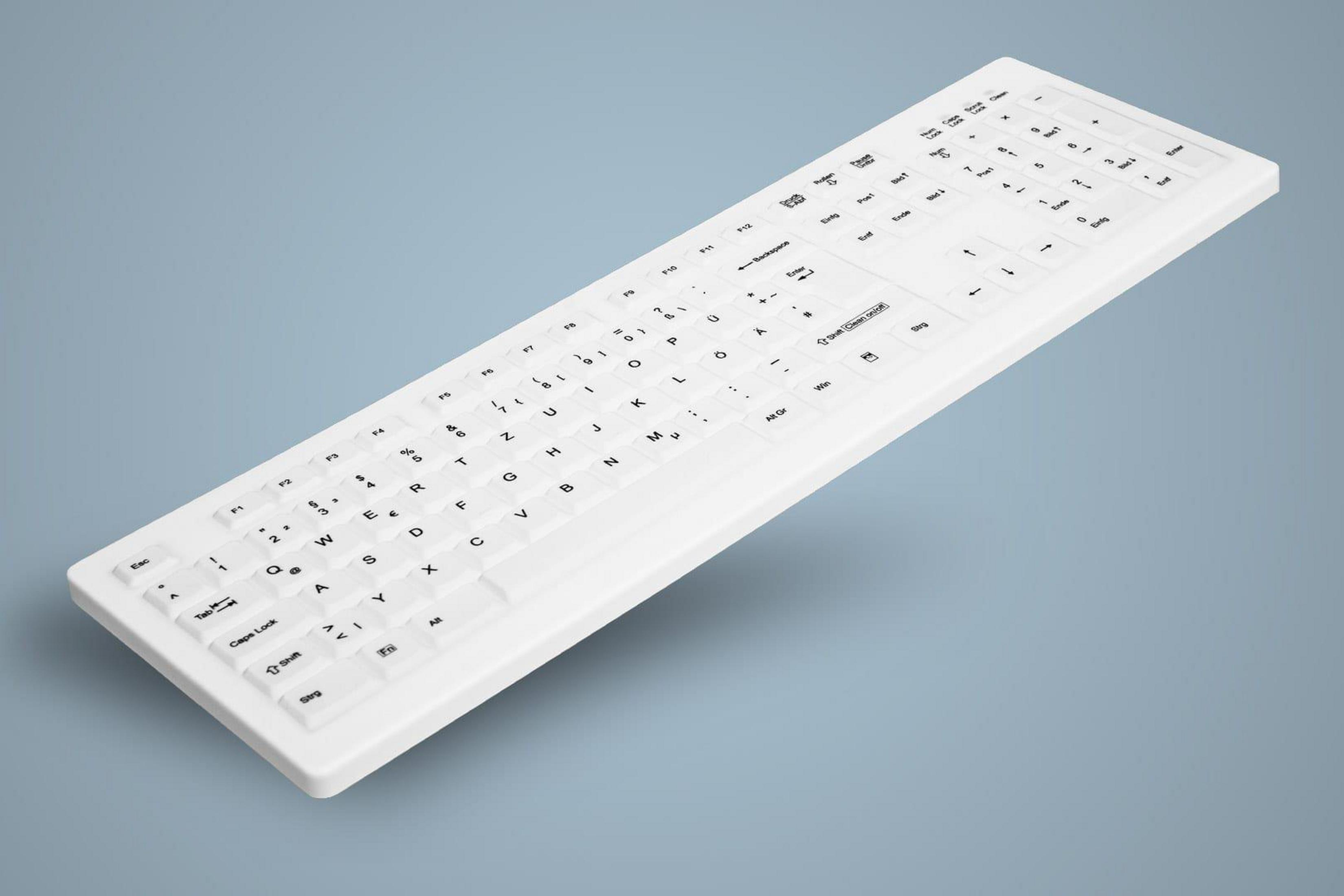 Eine weiße Tastatur mit Tastenbeschriftungen auf einer blauen Oberfläche. Sie ist schräg. Der Hintergrund ist blau.