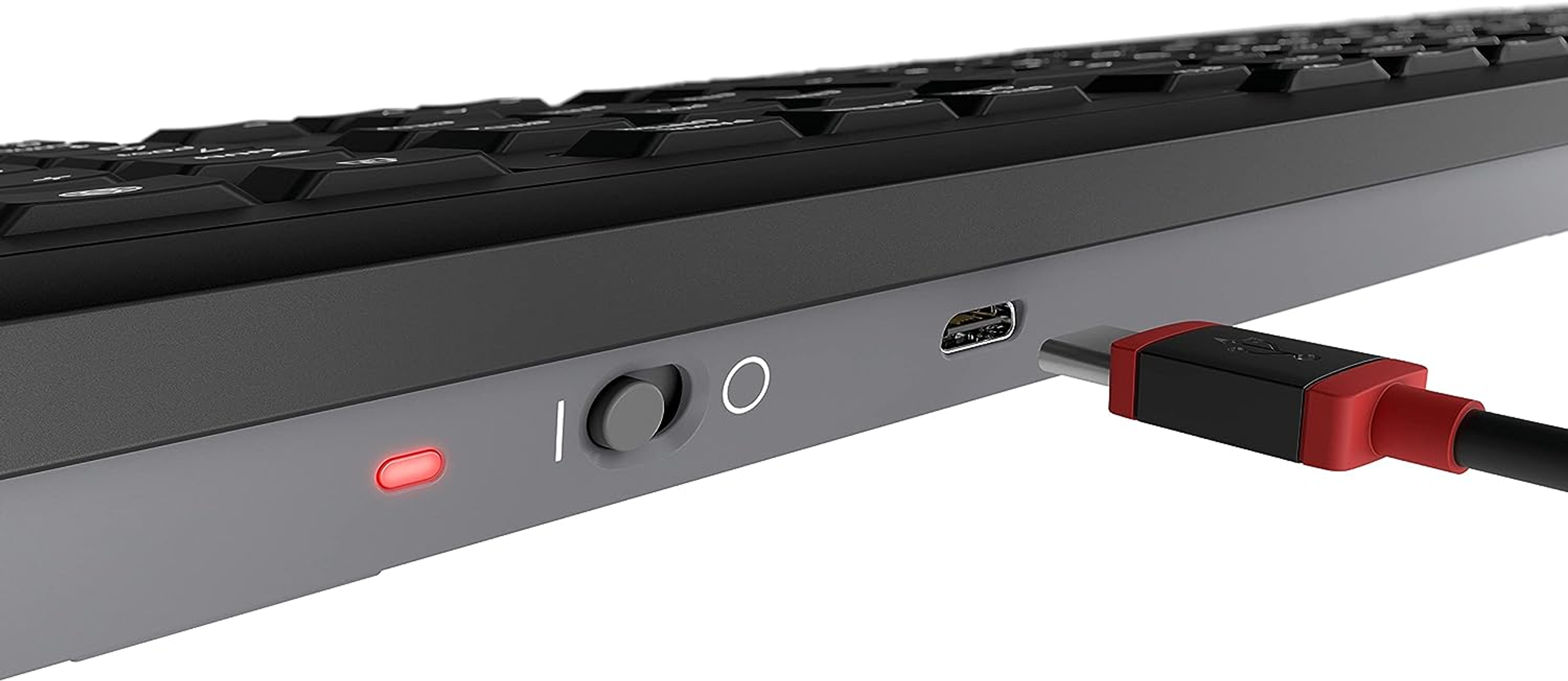 Zbliżenie czarno-szarej klawiatury z podłączonym kablem USB-C, włączony przełącznik zasilania.