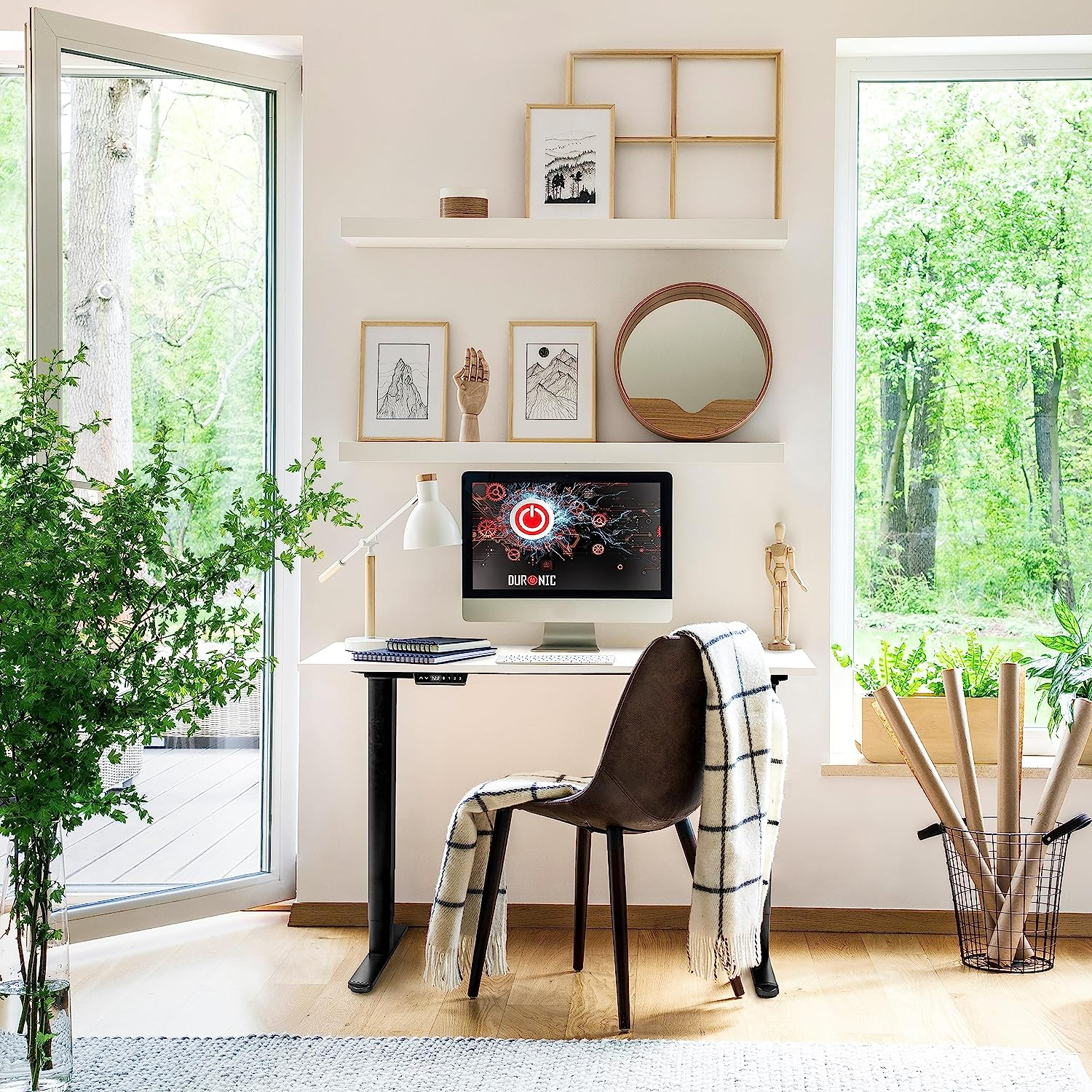 Ein modernes Heimbüro mit Stehpult, Monitor und Dekoration, mit Fenstern und Grün.