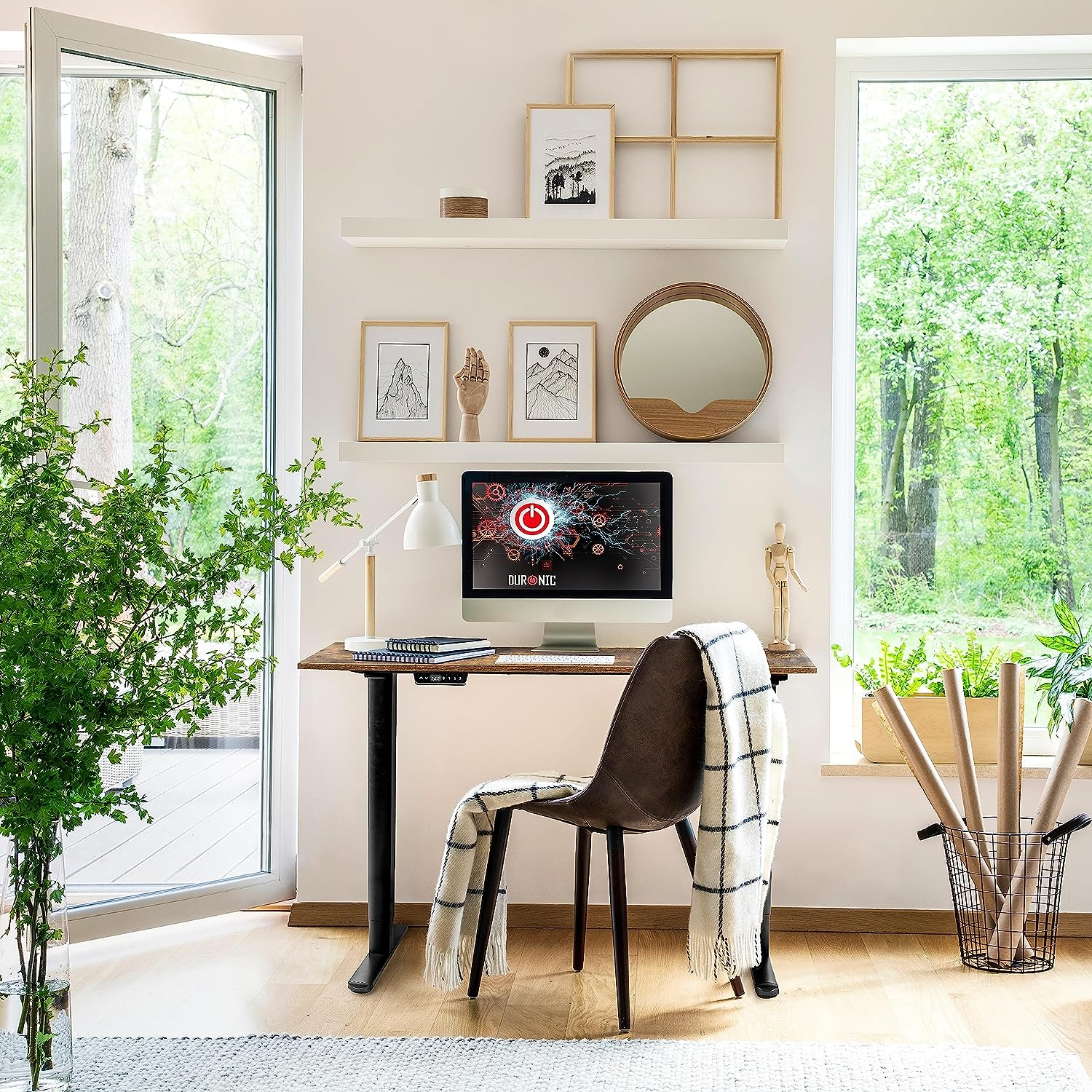 Ein Homeoffice mit Schreibtisch, Computer und Pflanzen. Ein Fenster zeigt einen grünen Wald.