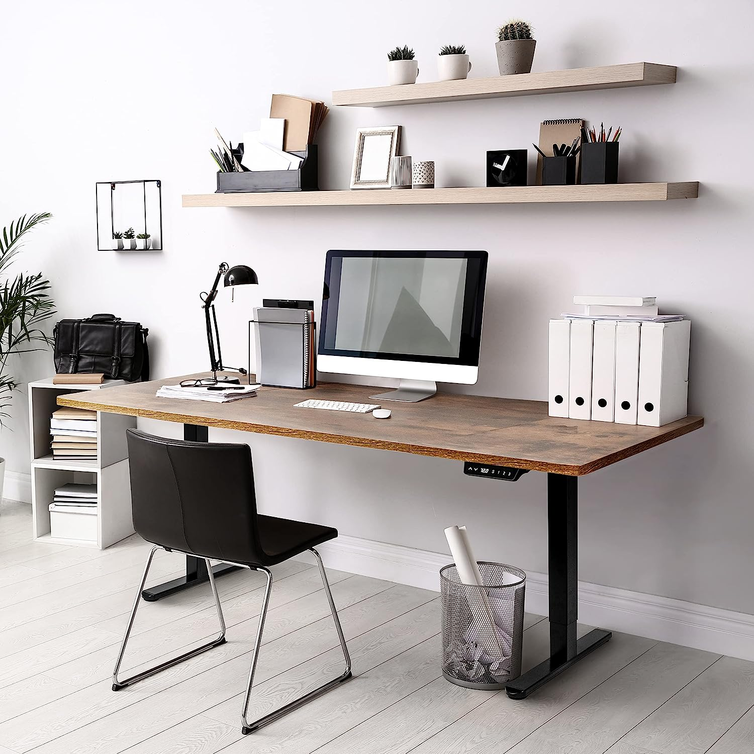 Ein moderner Bürotisch mit Computer, Lampe und verschiedenen Büromaterialien.
