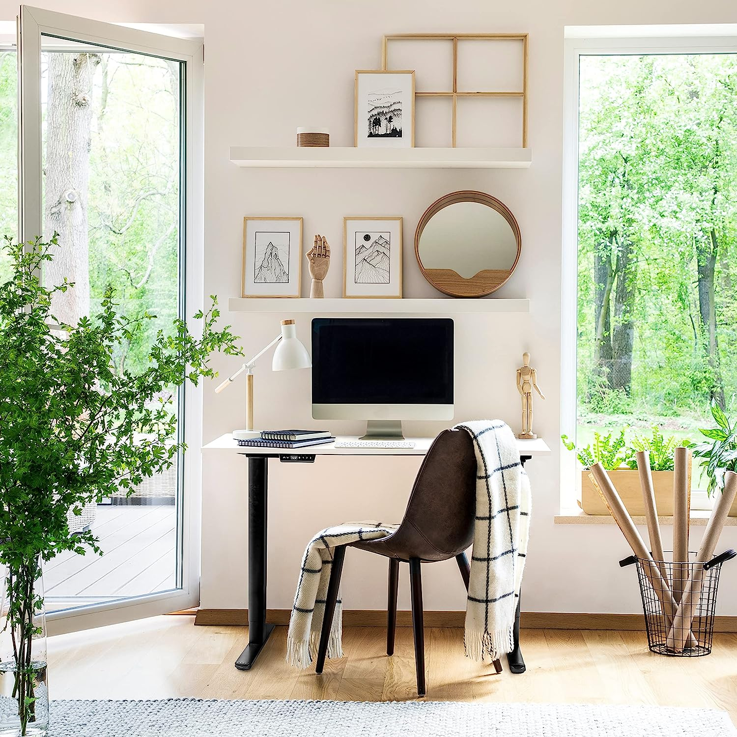 Ein Arbeitsplatz mit Computer, Stuhl, Regalen und Fenster mit grüner Aussicht.