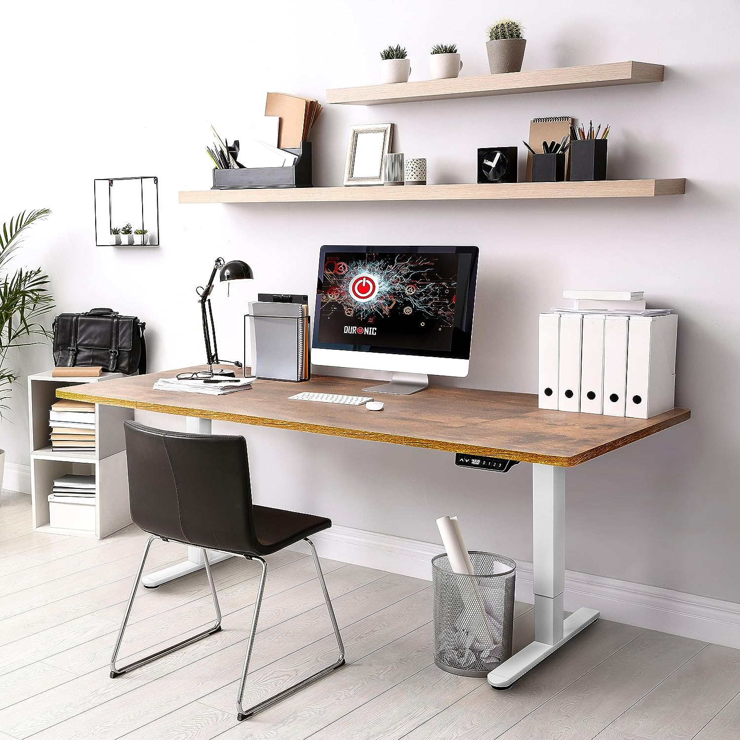 Ein moderner Bürotisch mit Computer, Regalen und Zubehör, gut beleuchtet und organisiert.