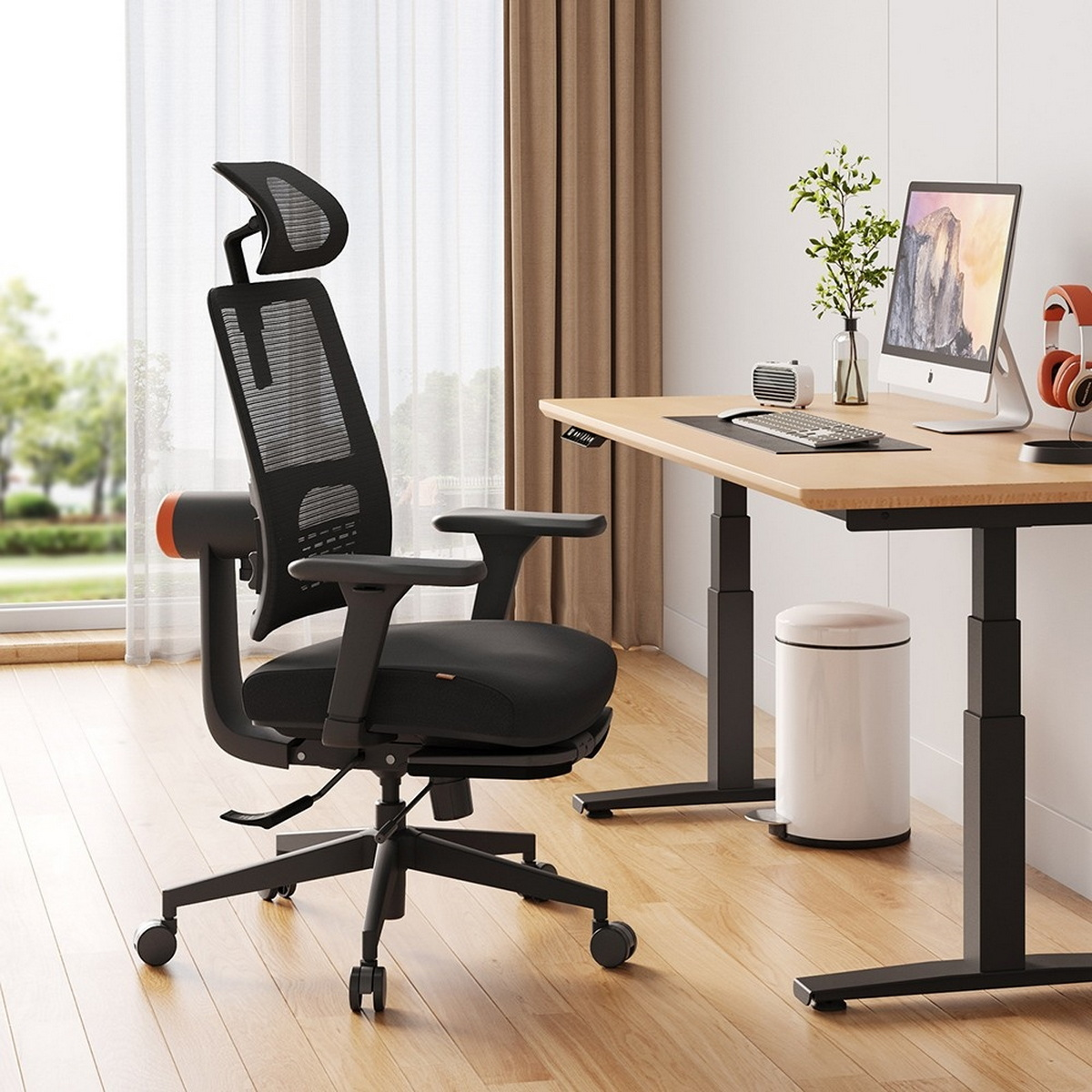Sedia da ufficio ergonomica nera con poggiatesta, braccioli e base nera, in un ufficio.