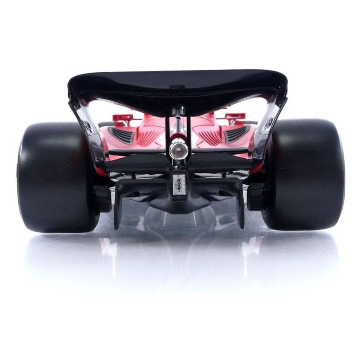 Widok z tyłu czerwonego samochodu wyścigowego z czarnymi oponami i skrzydłem.