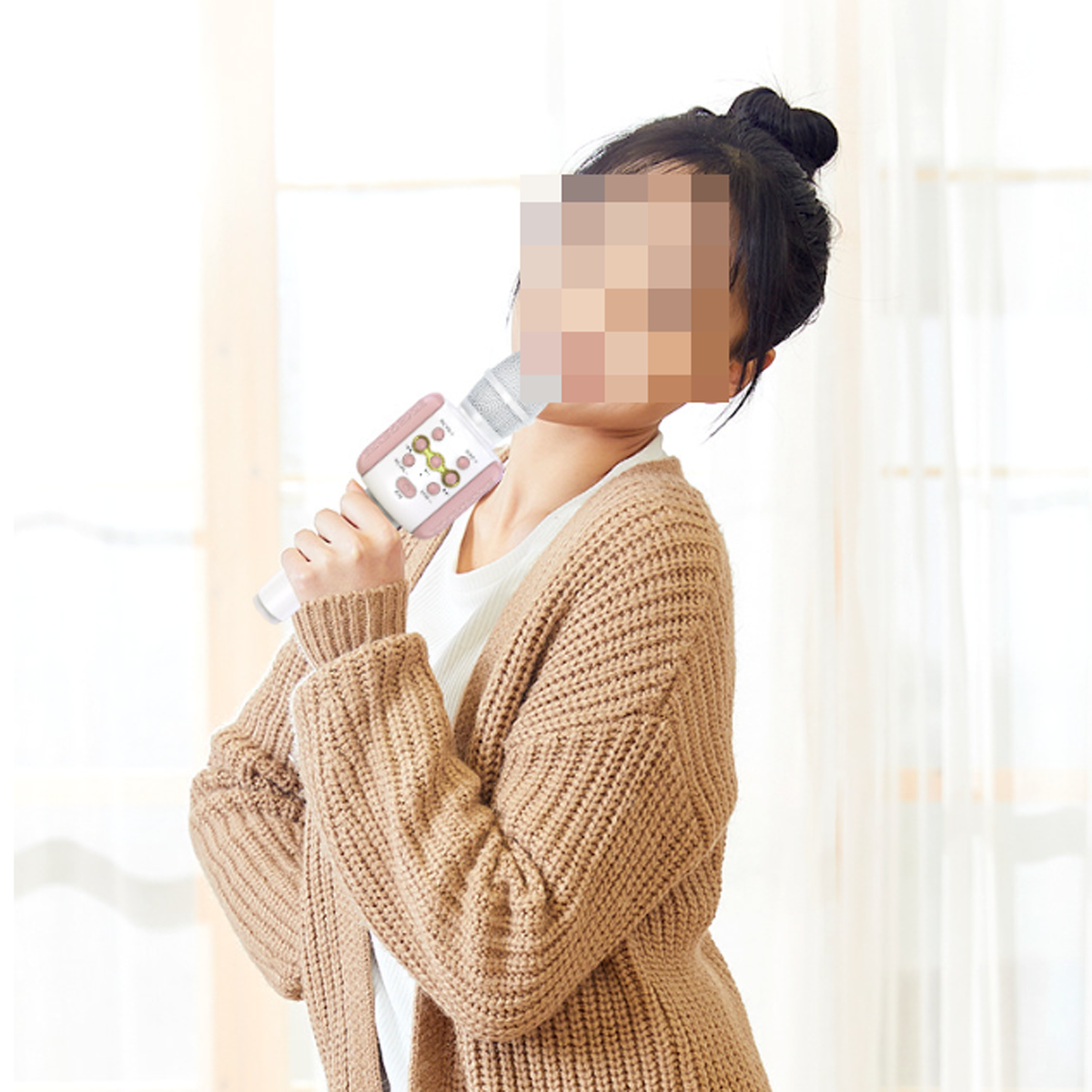 Eine Frau in einem braunen Pullover hält ein weißes und rosa Mikrofon, verschwommenes Gesicht.