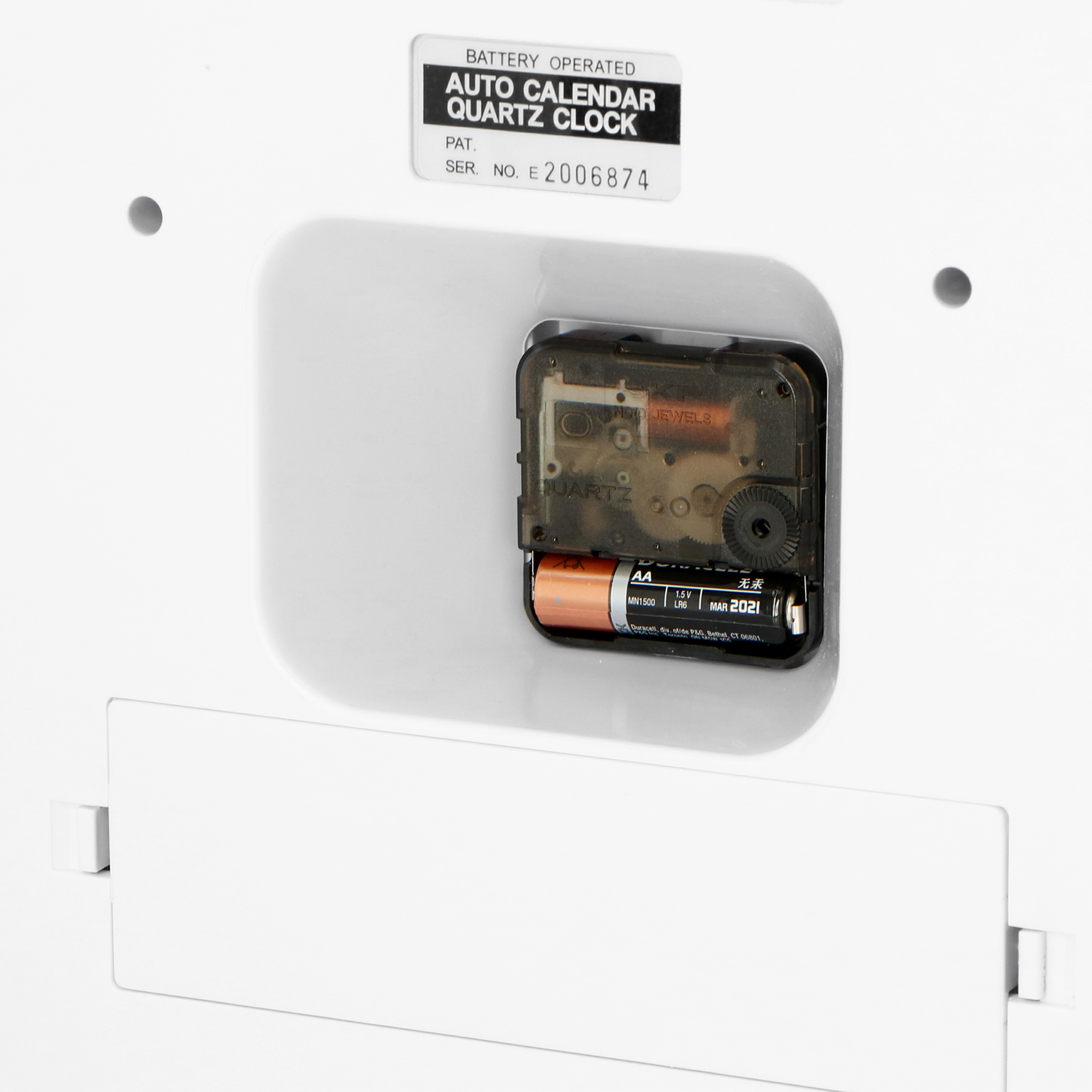 Rückseite einer weißen Uhr. Ein Quarzwerk und eine AA-Batterie sind sichtbar.