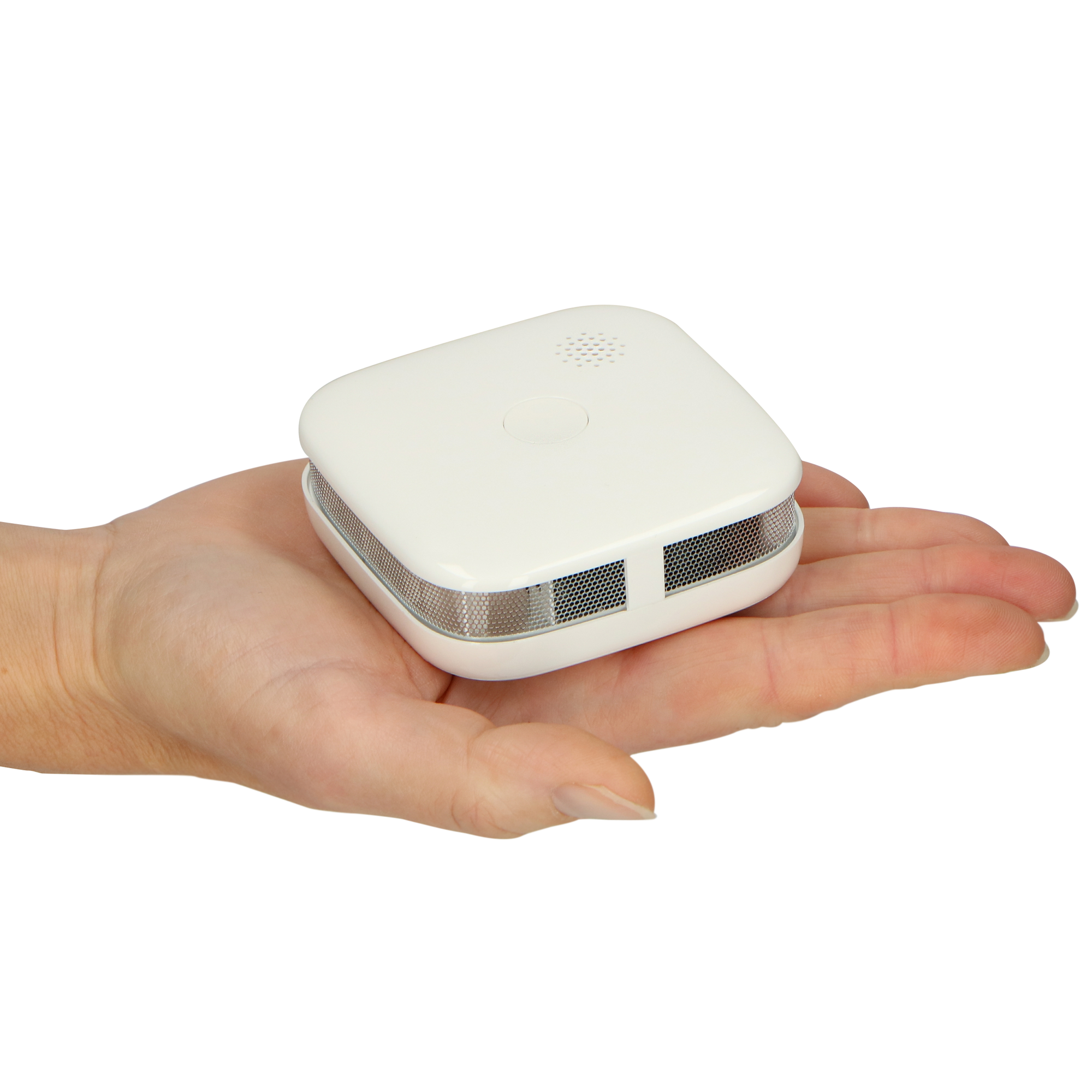 Biały czujnik dymu trzymany w dłoni, z widoczną siatką i otworami wentylacyjnymi.