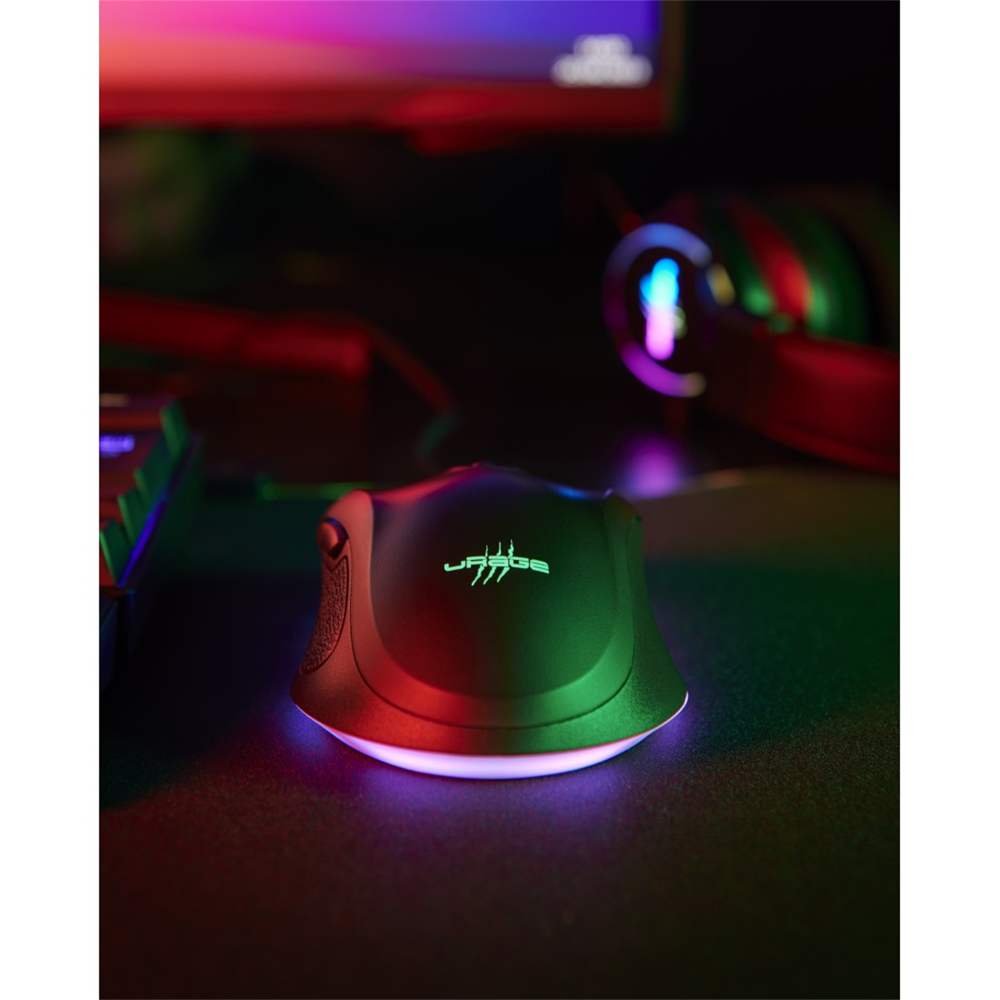 Mouse da gaming nero con illuminazione RGB. Sfondo: scrivania scura con monitor e cuffie.