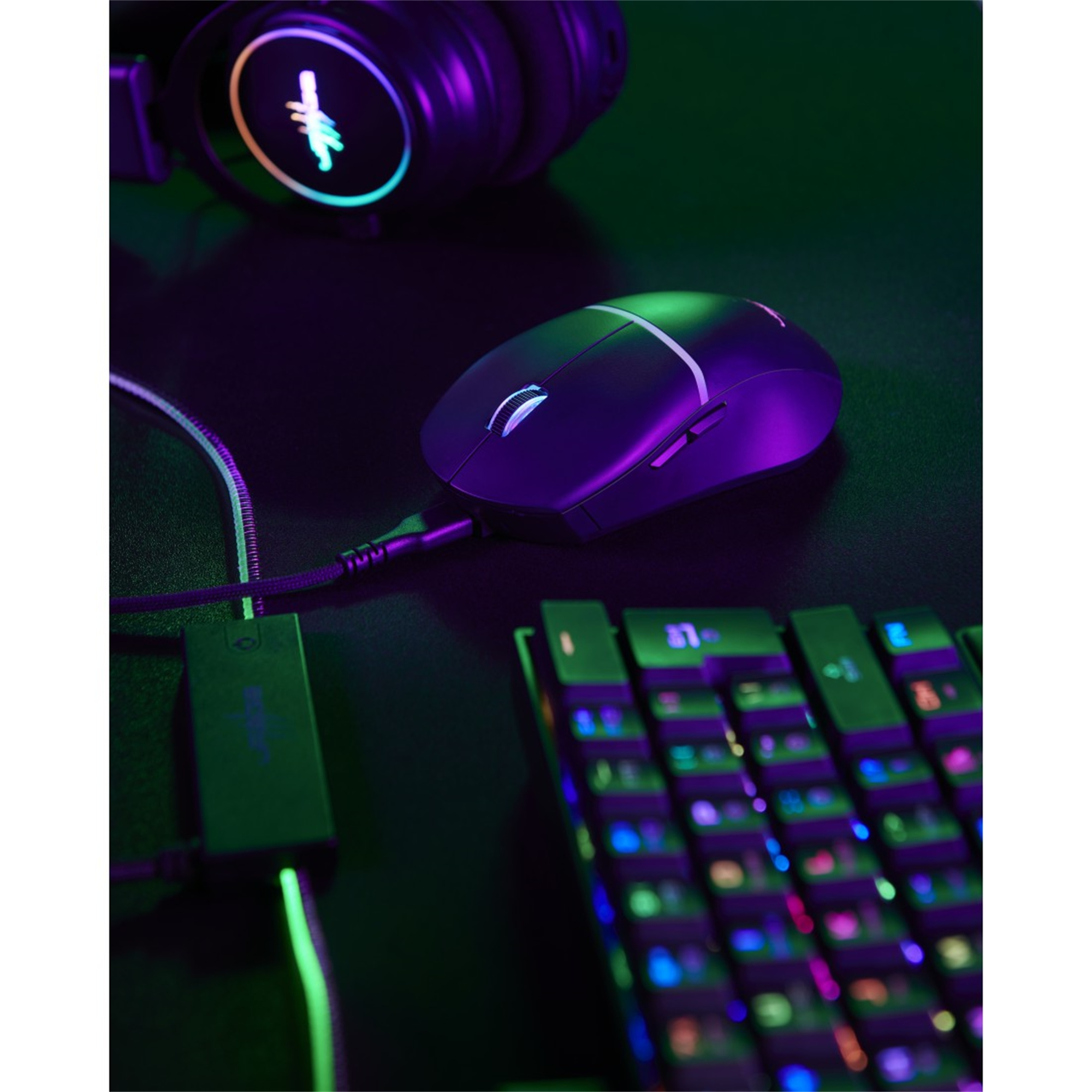 Gaming-Maus und -Tastatur mit Lichtern auf dunkler Oberfläche. Kopfhörer sind im unscharfen Hintergrund.