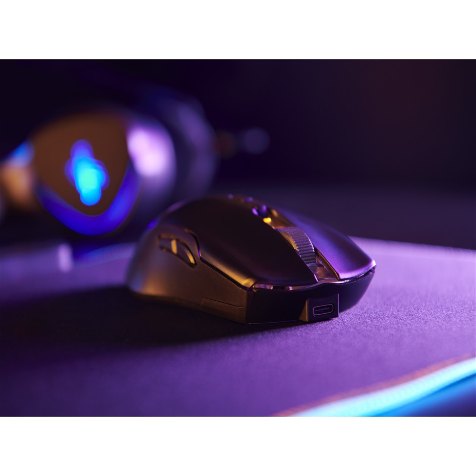 Eine Gaming-Maus mit violetter Beleuchtung, aus einem seitlichen Winkel gesehen.