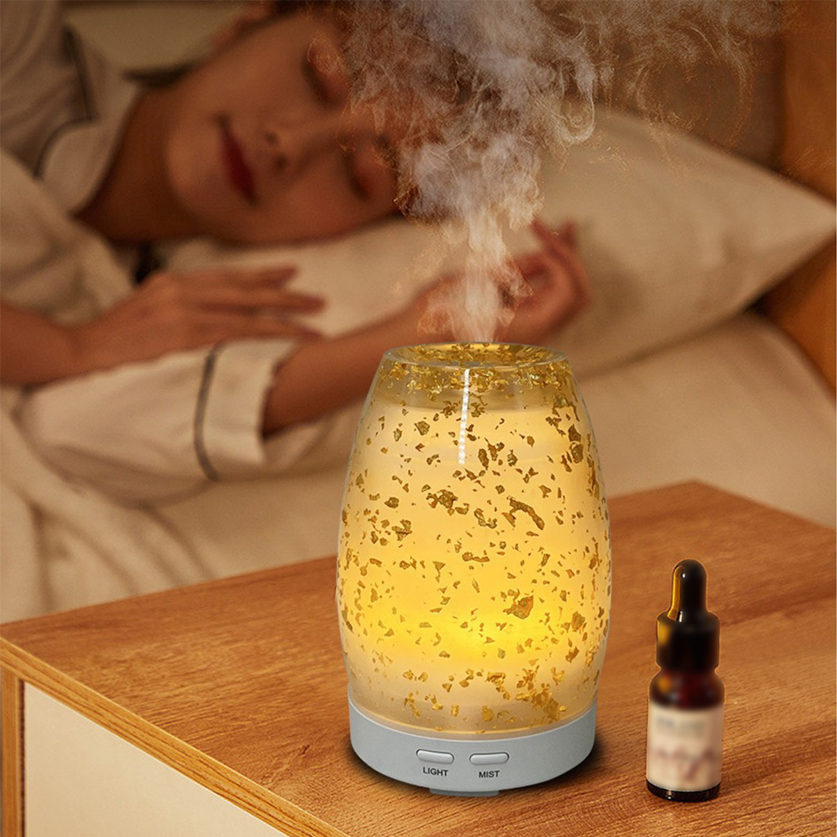 Frau schläft neben einem Aromadiffusor. Es ist ein Glas mit Goldflocken darin.