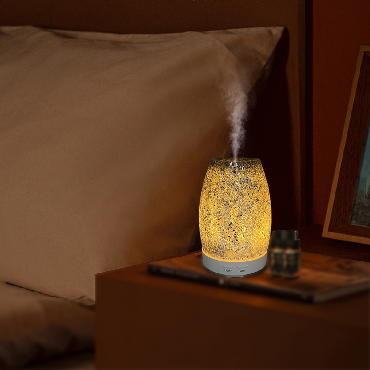 Beleuchteter Diffusor, der Dampf abgibt. Er steht auf einem Tisch neben Bett u. Rahmen.